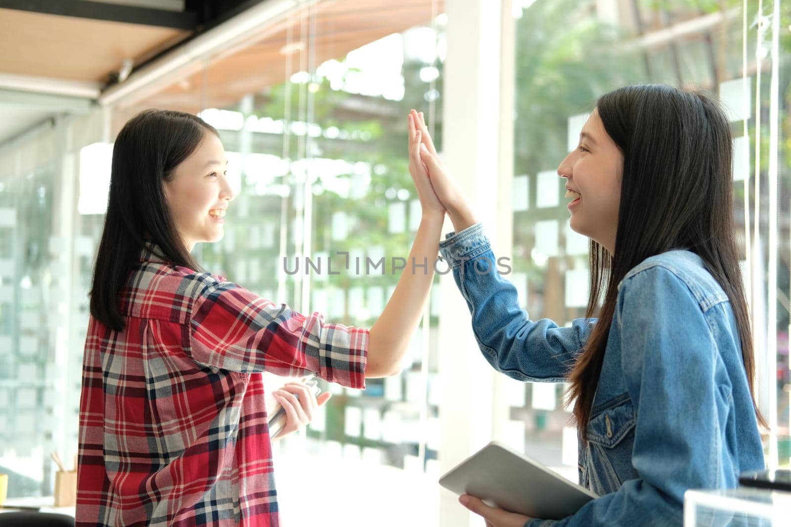 girl teenager giving high five touching hands together. teamwork friendship amity concept