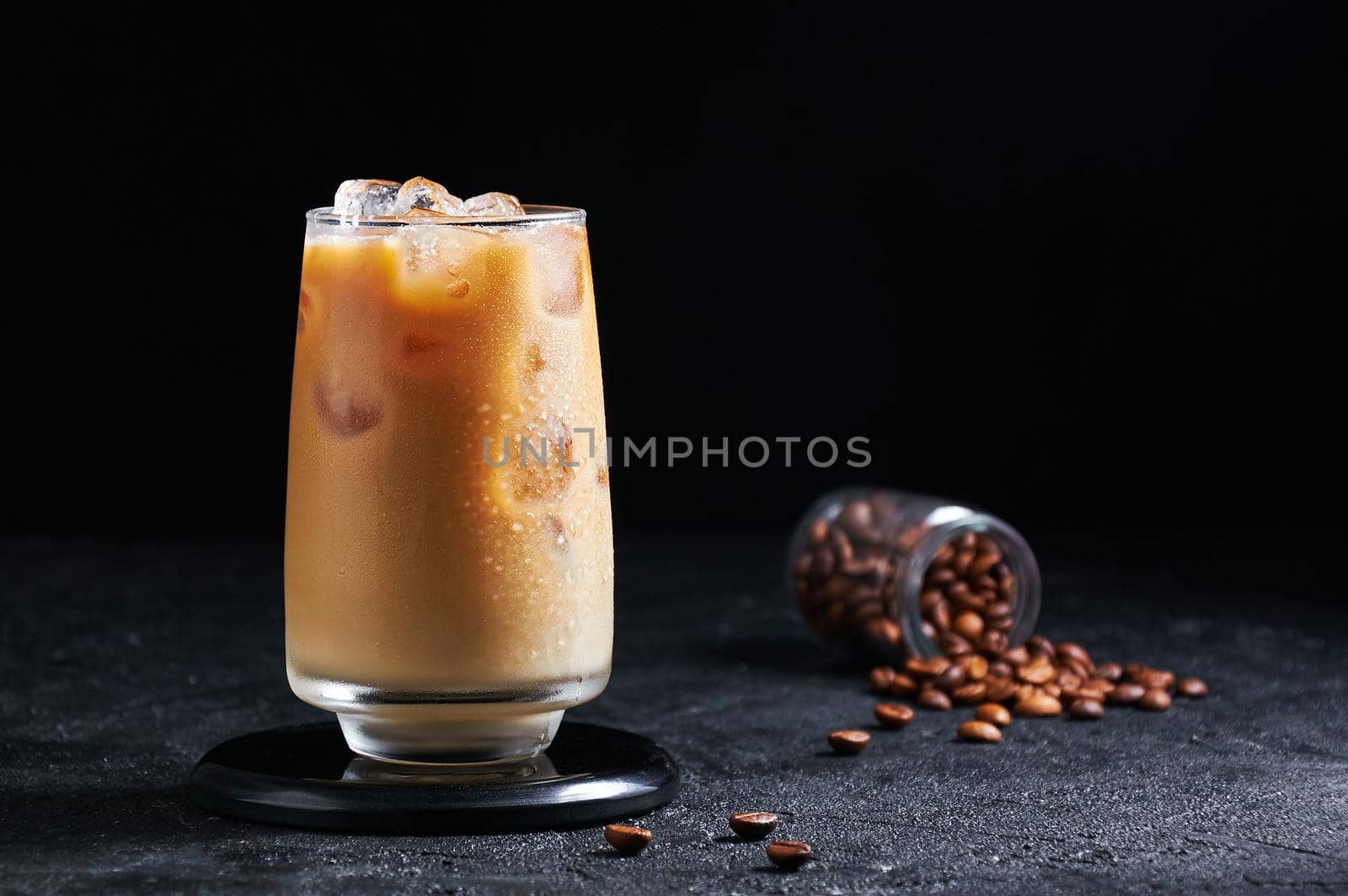 Iced Coffee with Milk in Tall Glass on Dark Background. Concept Refreshing Summer Drink by Svetlana_Belozerova