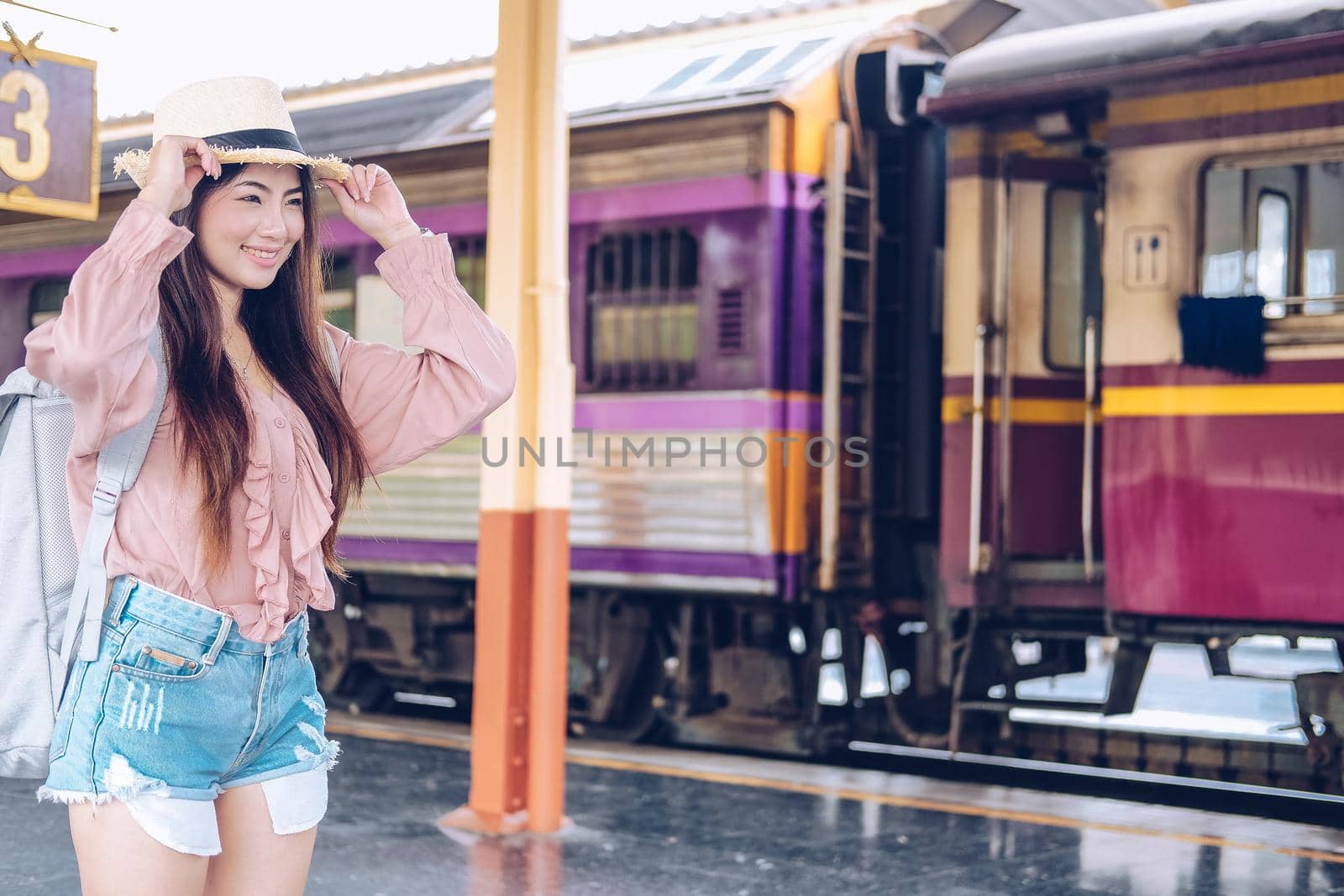 young asian woman  backpacker traveler with backpack at train station. journey trip travel concept