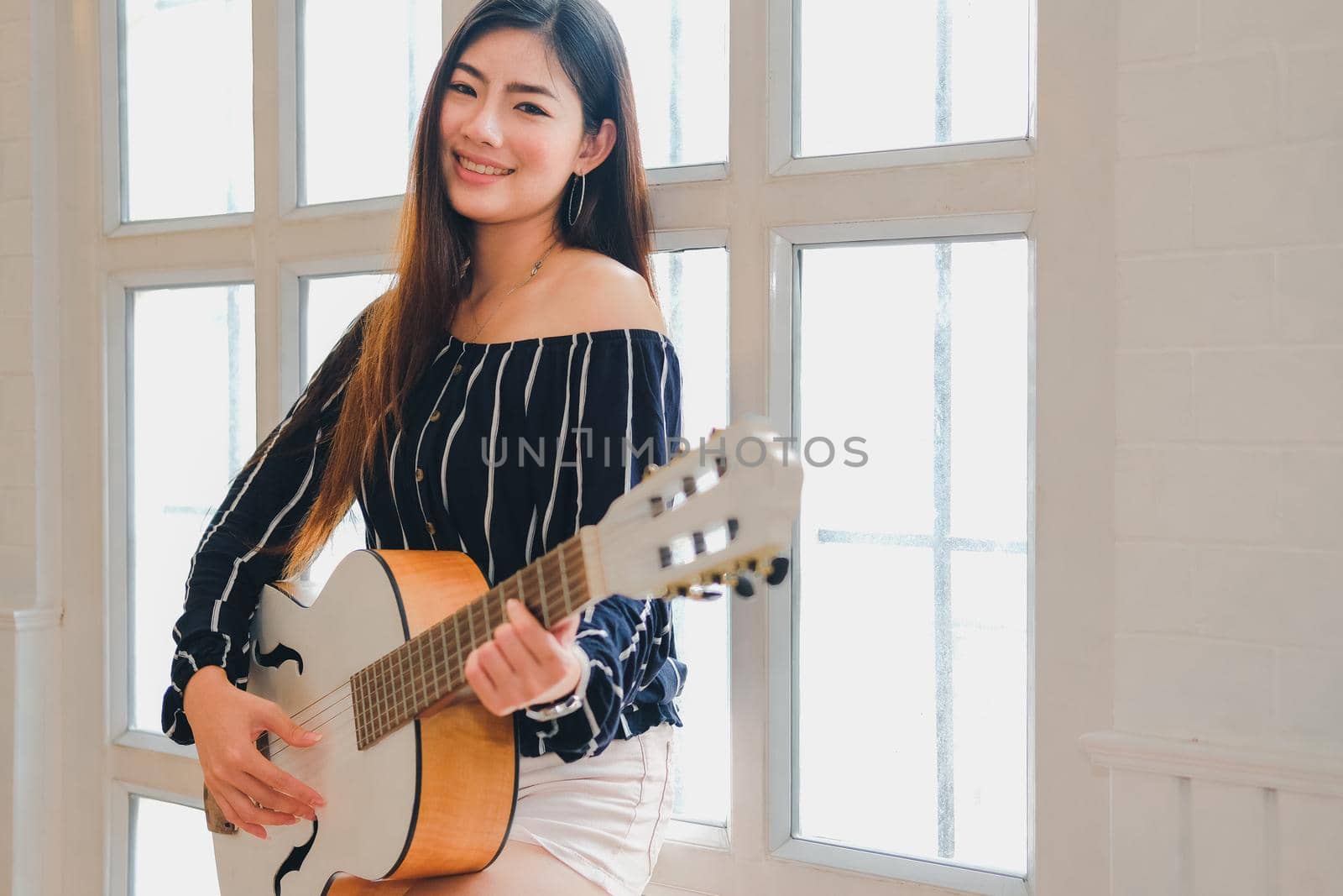 woman playing guitar at home.  leisure lifestyle concept