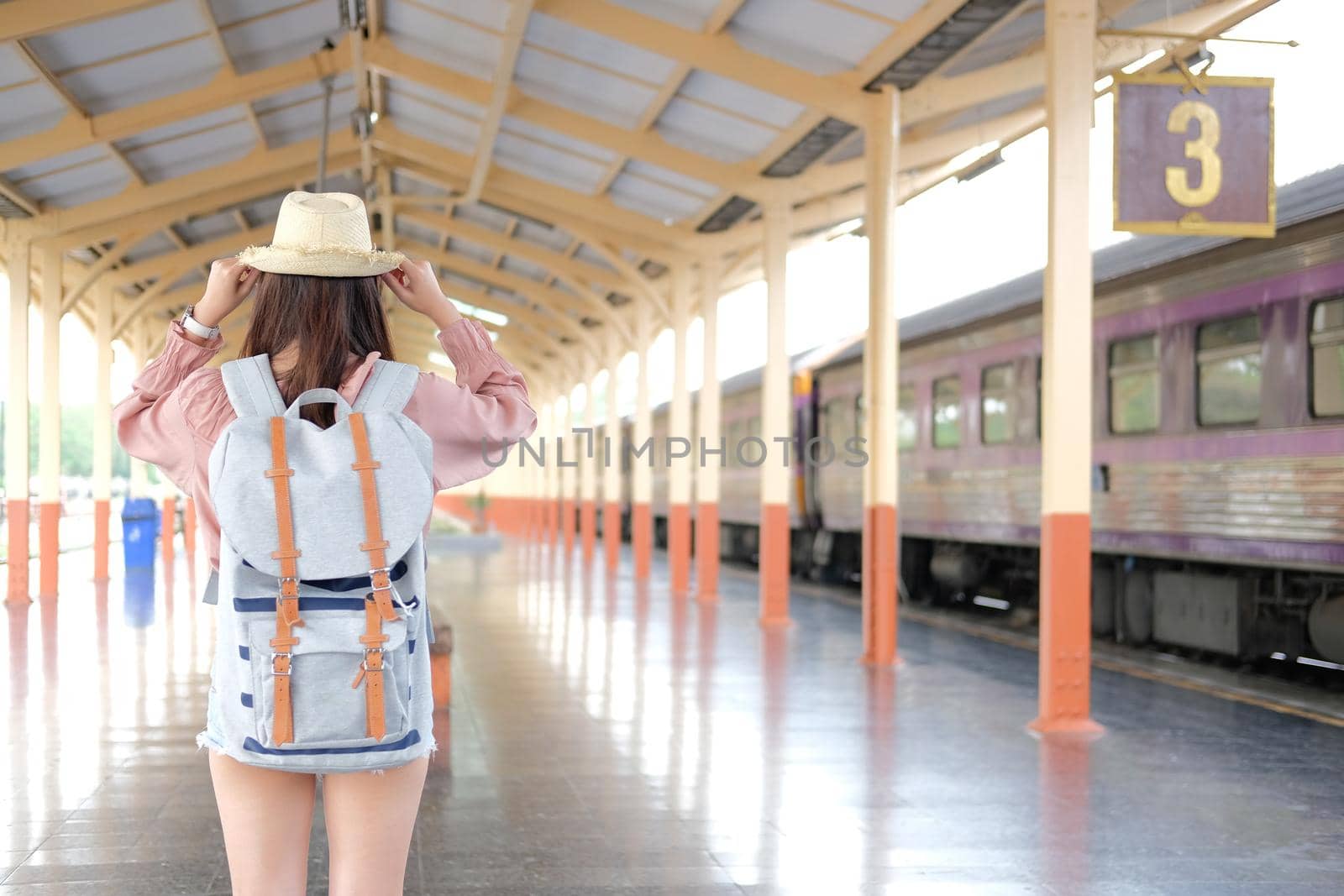 young asian woman  backpacker traveler with backpack at train station. journey trip travel concept