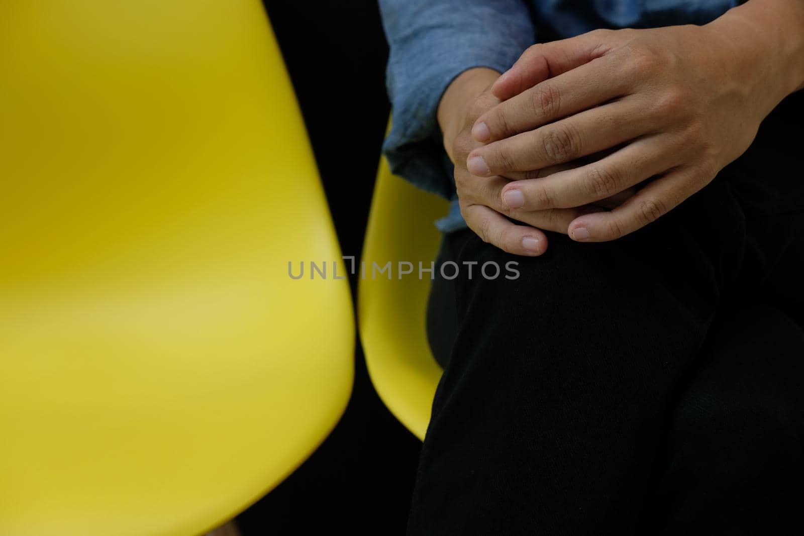 man wearing blue shirt sitting resting on yellow chair at home