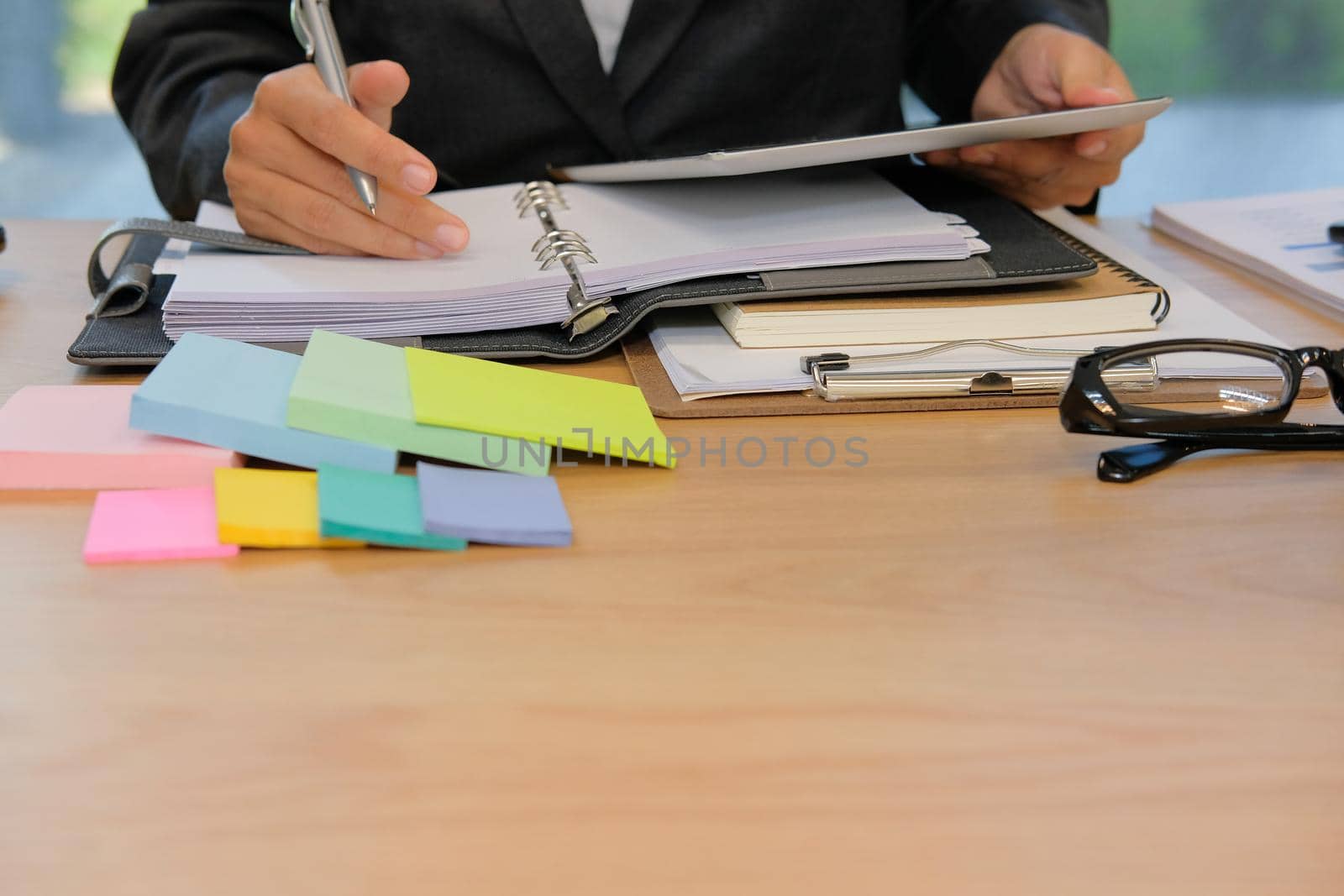 man organizing plan with notebook & tablet. businessman working  at workplace coworking office