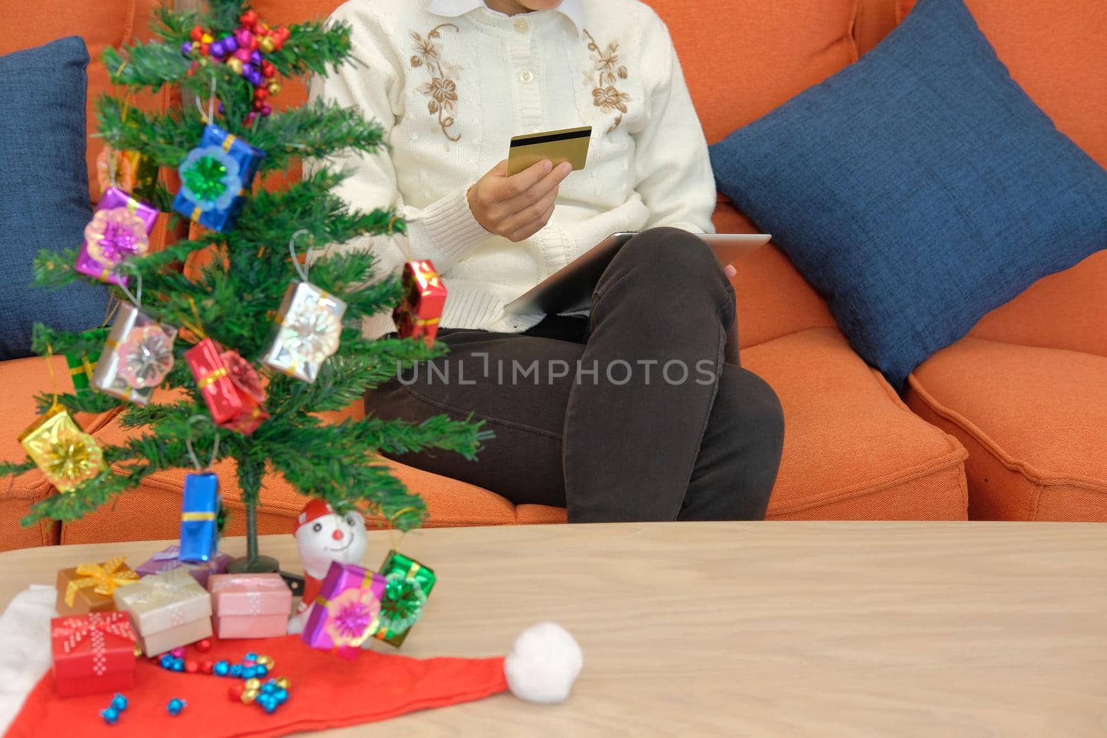 woman holding credit card & tablet for online shopping.  female buyer buying christmas gift on internet. new year holiday merry xmas celebration