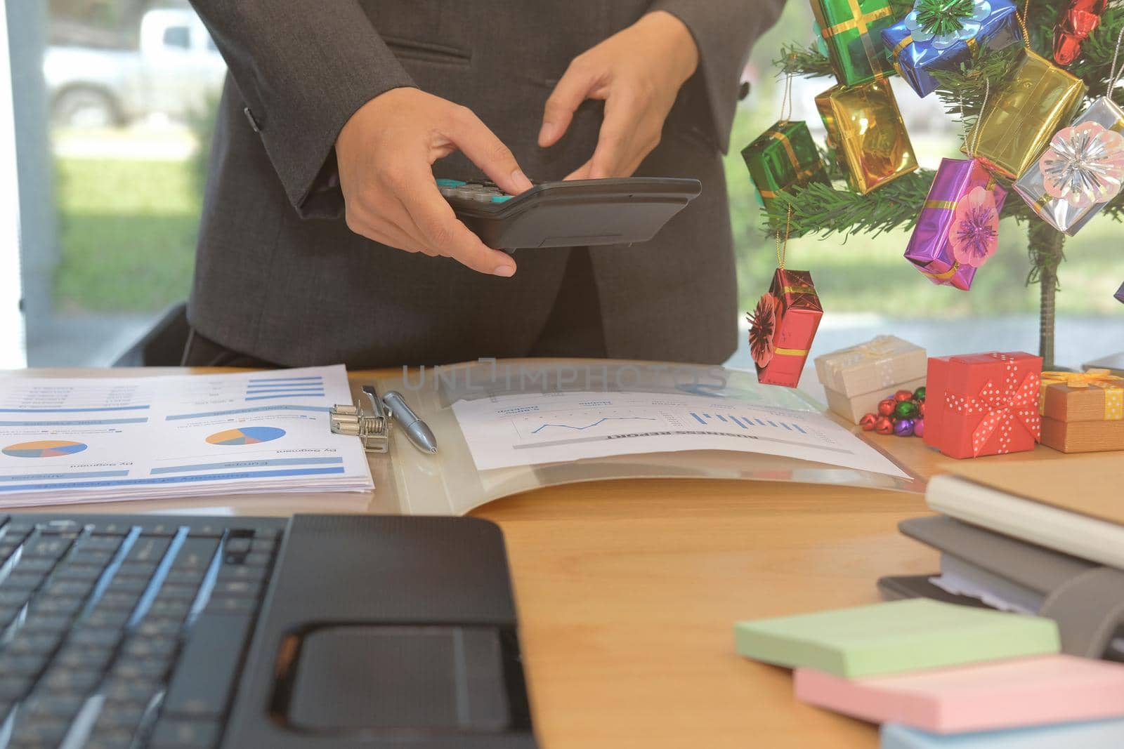 financial adviser working with calculator at office. accountant doing accounting & calculating revenue & budget. bookkeeper making calculation during christmas new year holiday