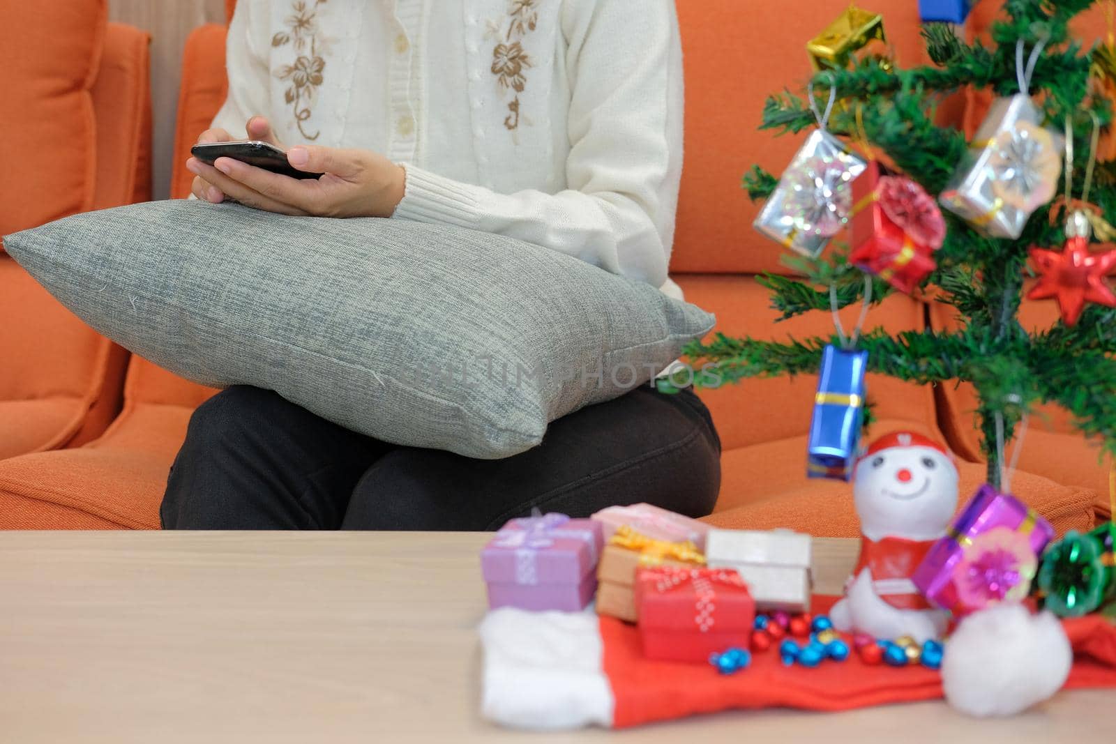 woman using smartphone at home. girl texting message on mobile phone during xmas. christmas holiday new year celebration season greetings