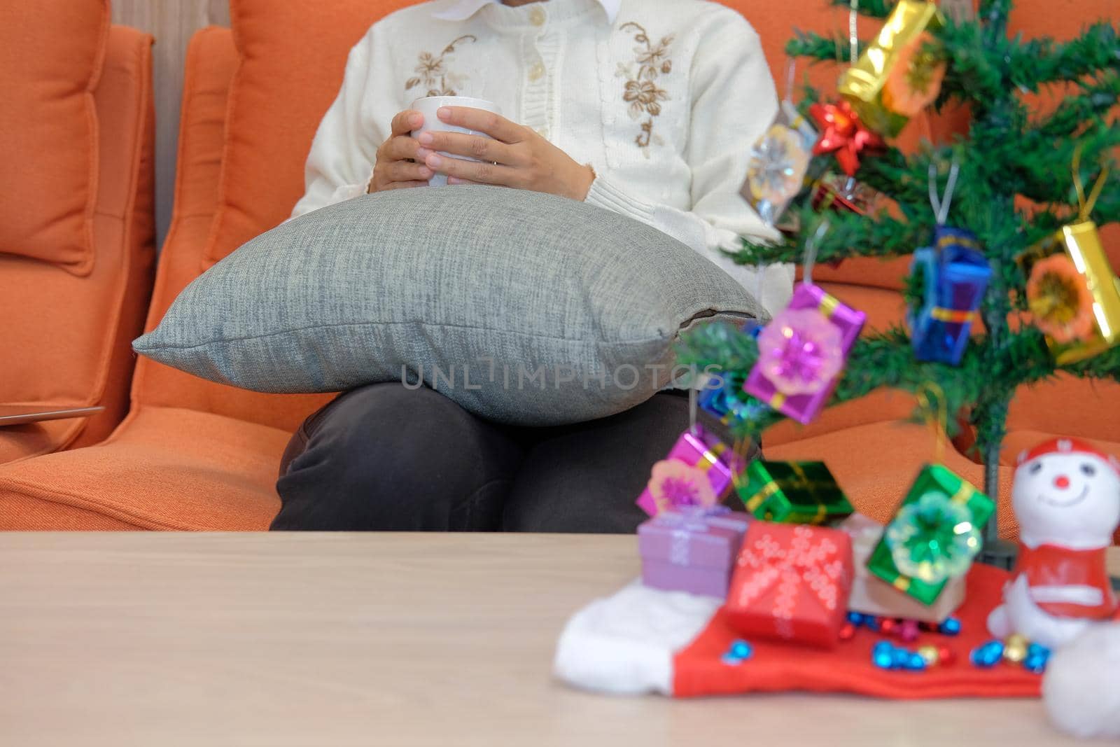 woman wearing cream cardigan holding coffee cup with gift box christmas tee. xmas new year celebration