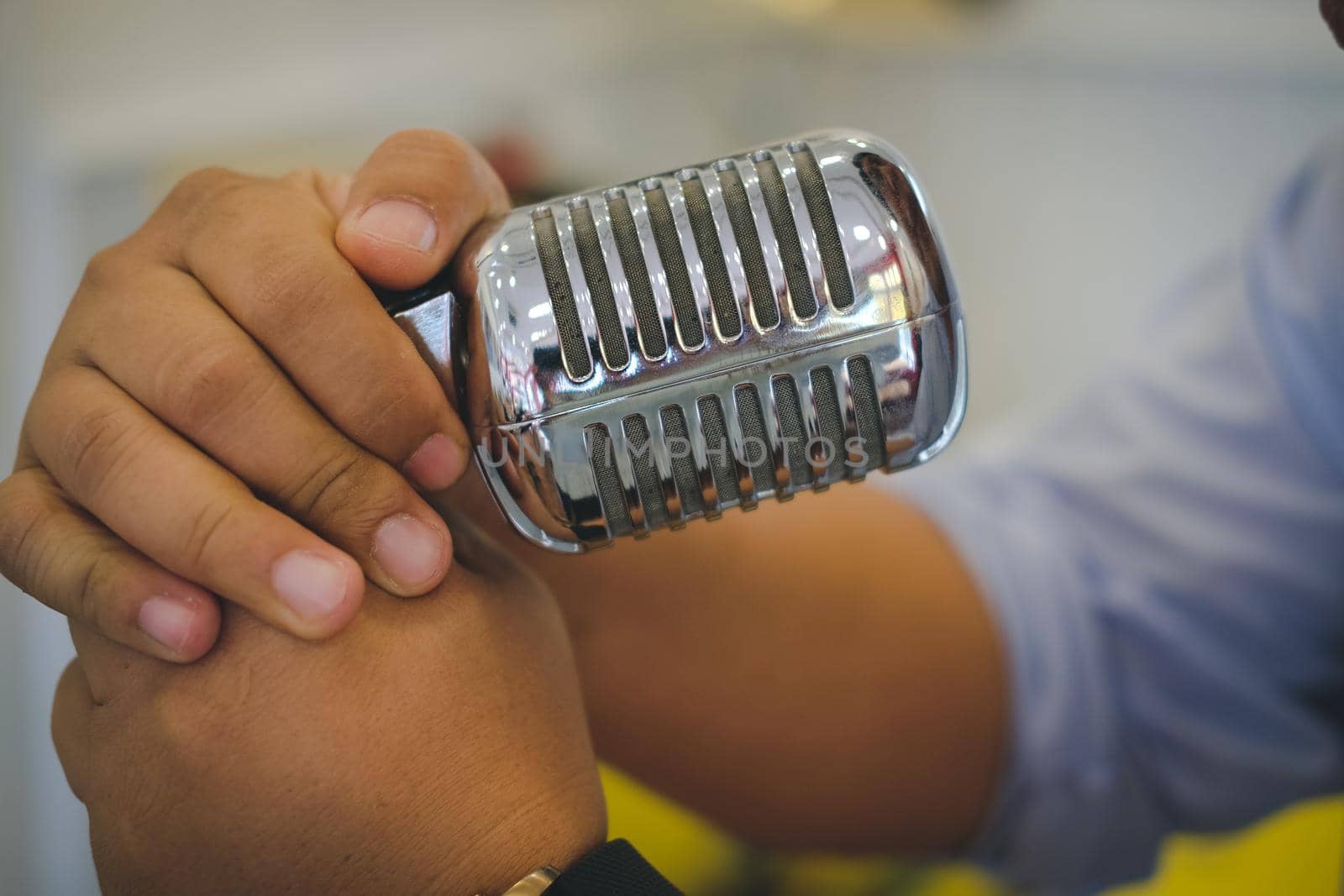 singer hand holding silver chrome metal vintage microphone