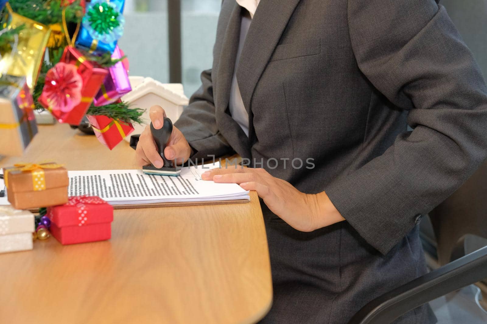 real estate agent using stamper for stamping approved on mortgage loan contract agreement document during christmas