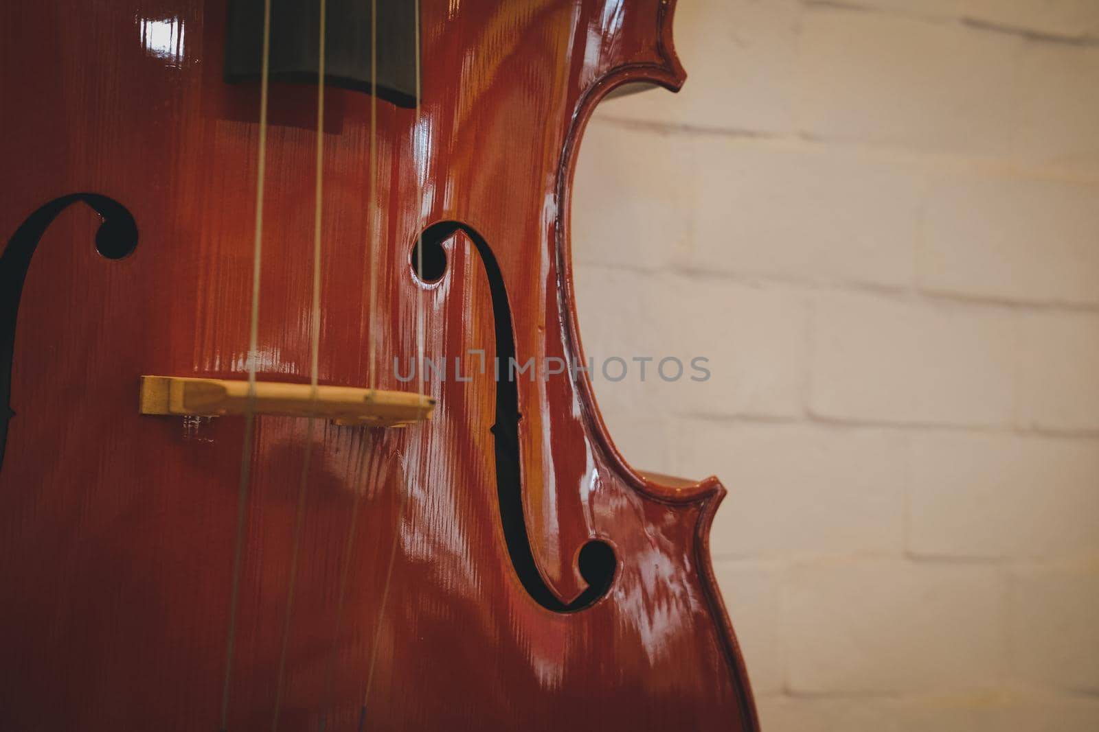 brown cello near red wall. musical instrument