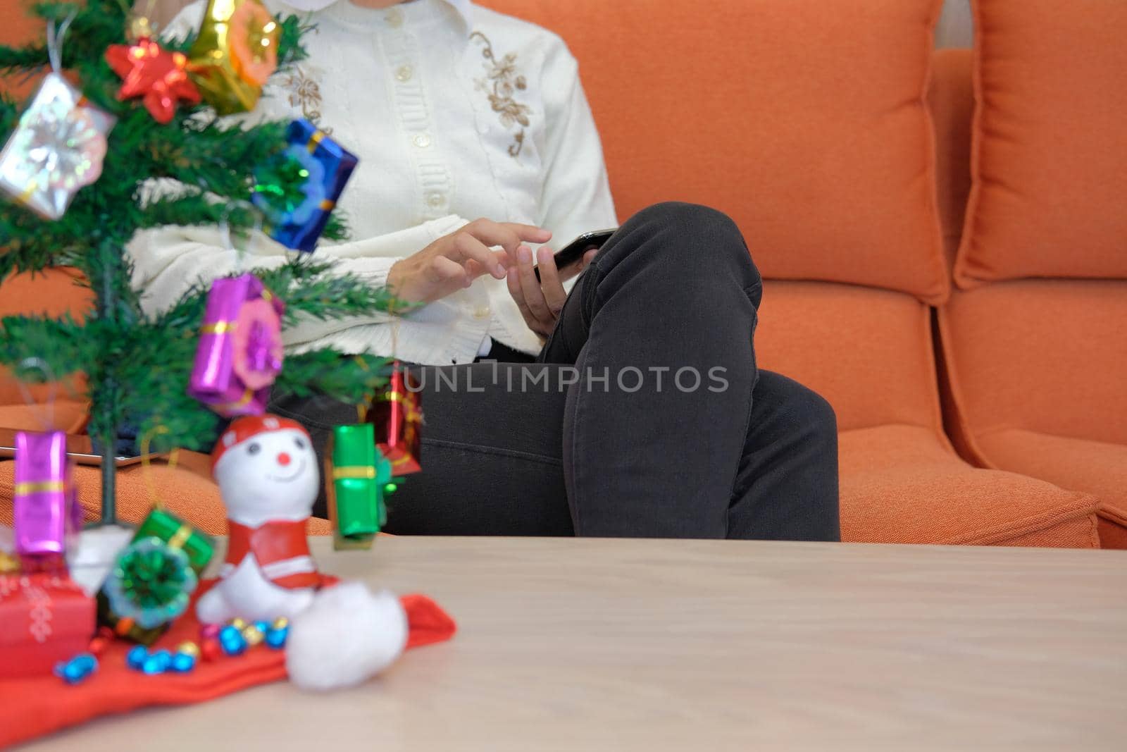 woman using smartphone at home. girl texting message on mobile phone during xmas. christmas holiday new year celebration season greetings