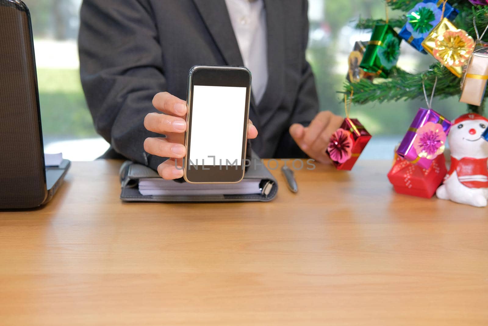 businessman showing white screen of smart phone during christmas new year holiday