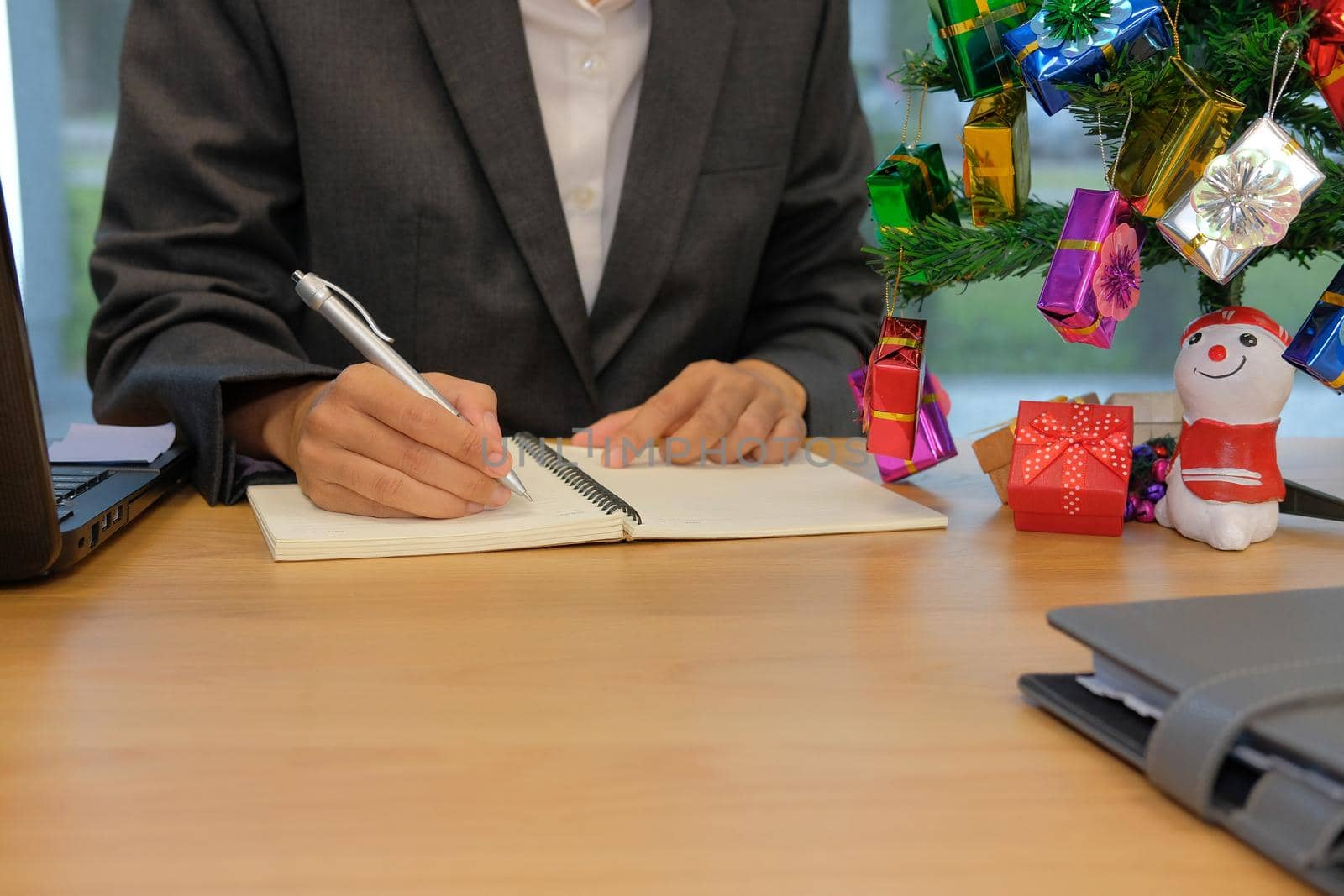 man writing reminder schedule note on notebook. businessman working organizing plan at workplace office during christmas new year holiday