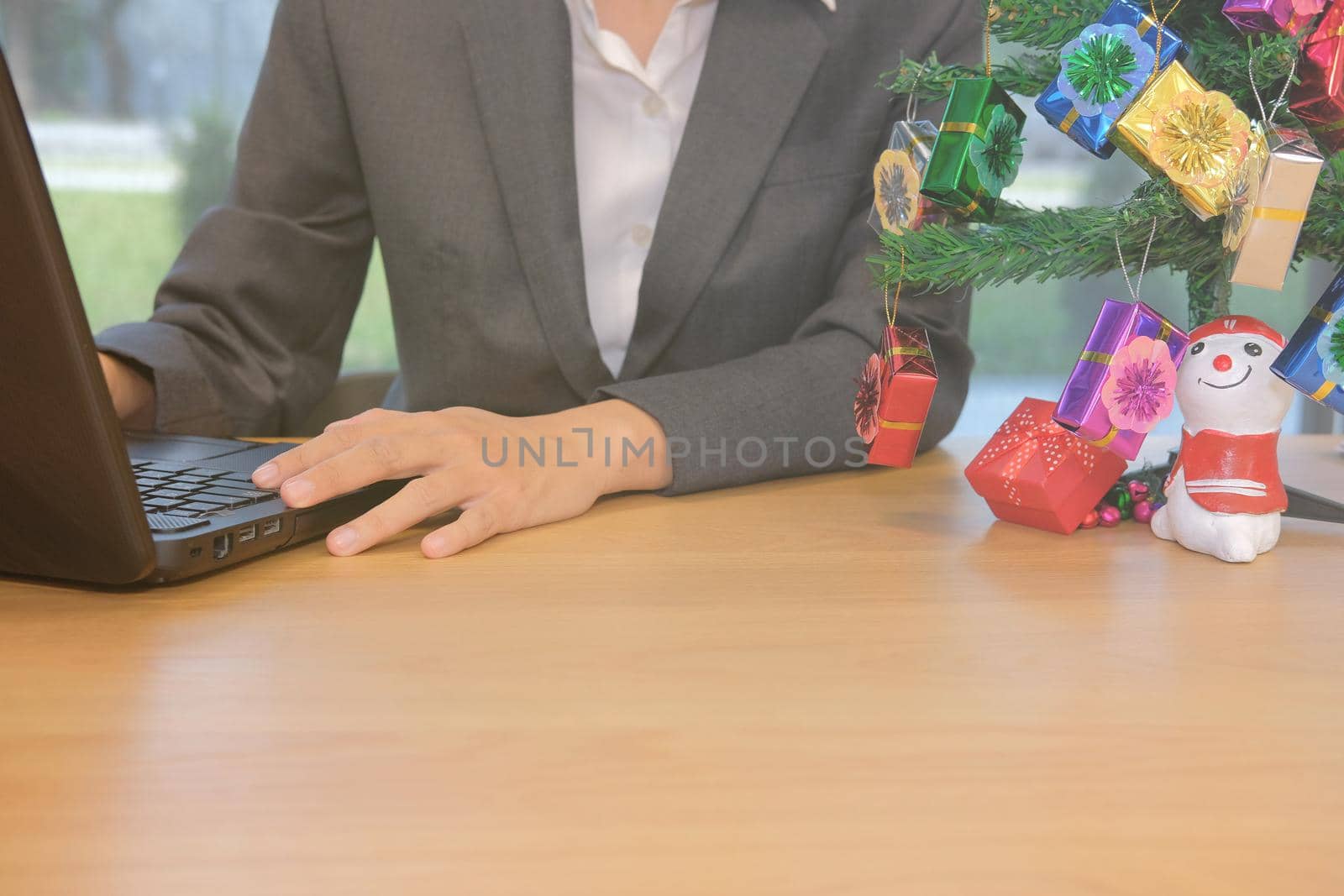 businessman using computer. startup man working with laptop with decorated christmas tree on office desk during xmas holiday
