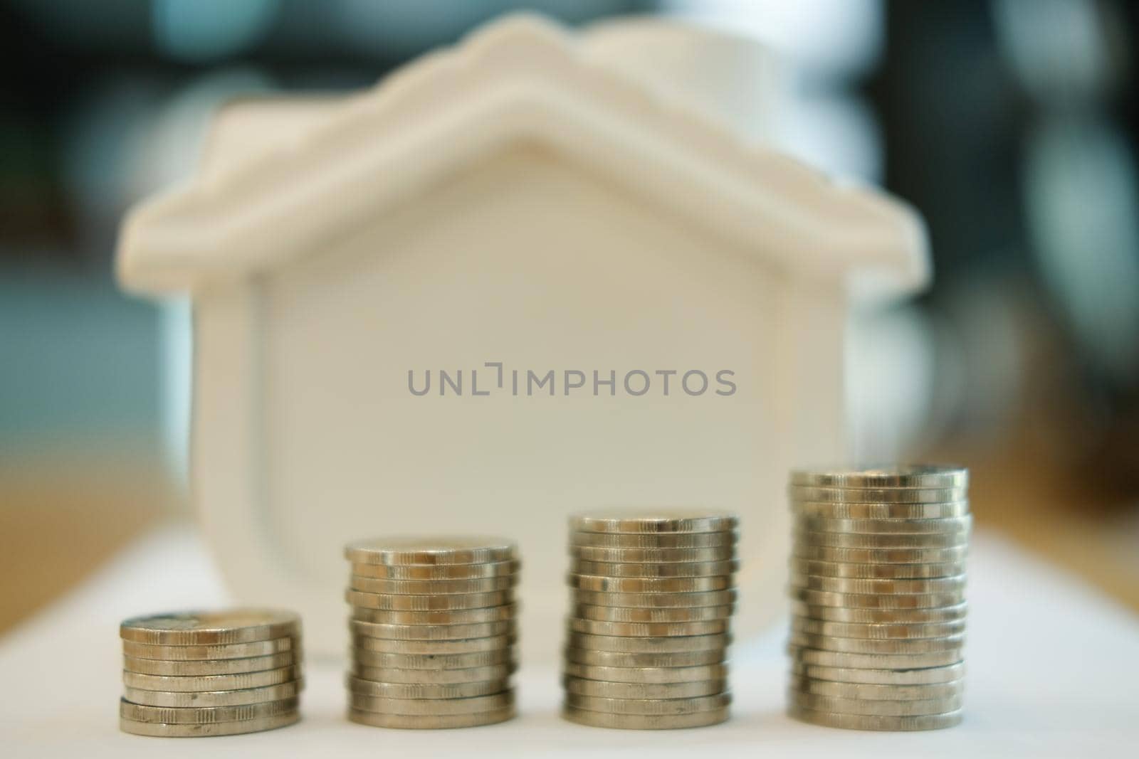 coin stack and house model. plan for property purchase. mortgage loan, real estate investment concept