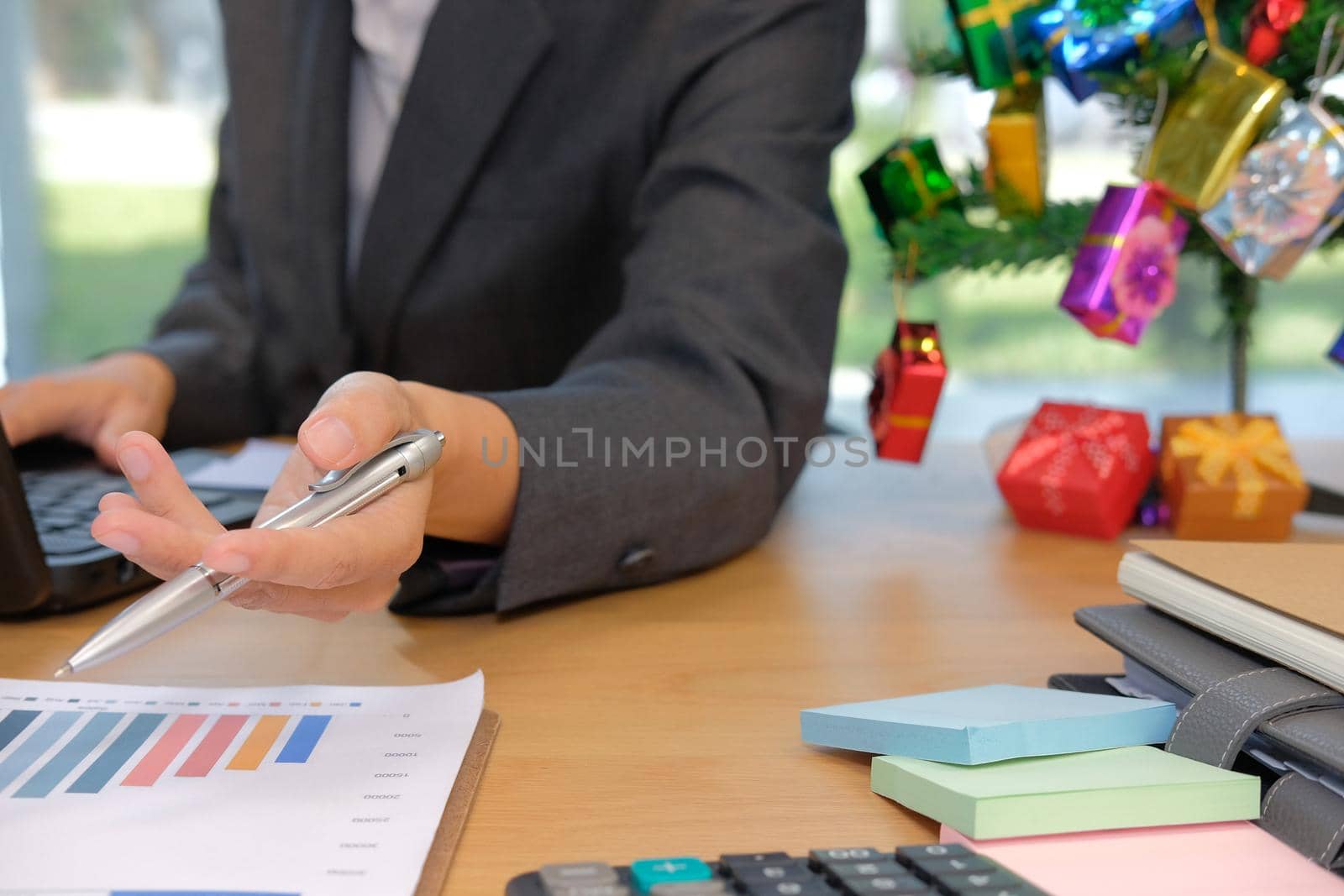 businessman working with document & computer. startup man discussing financial data at workplace during christmas new year holiday  by pp99