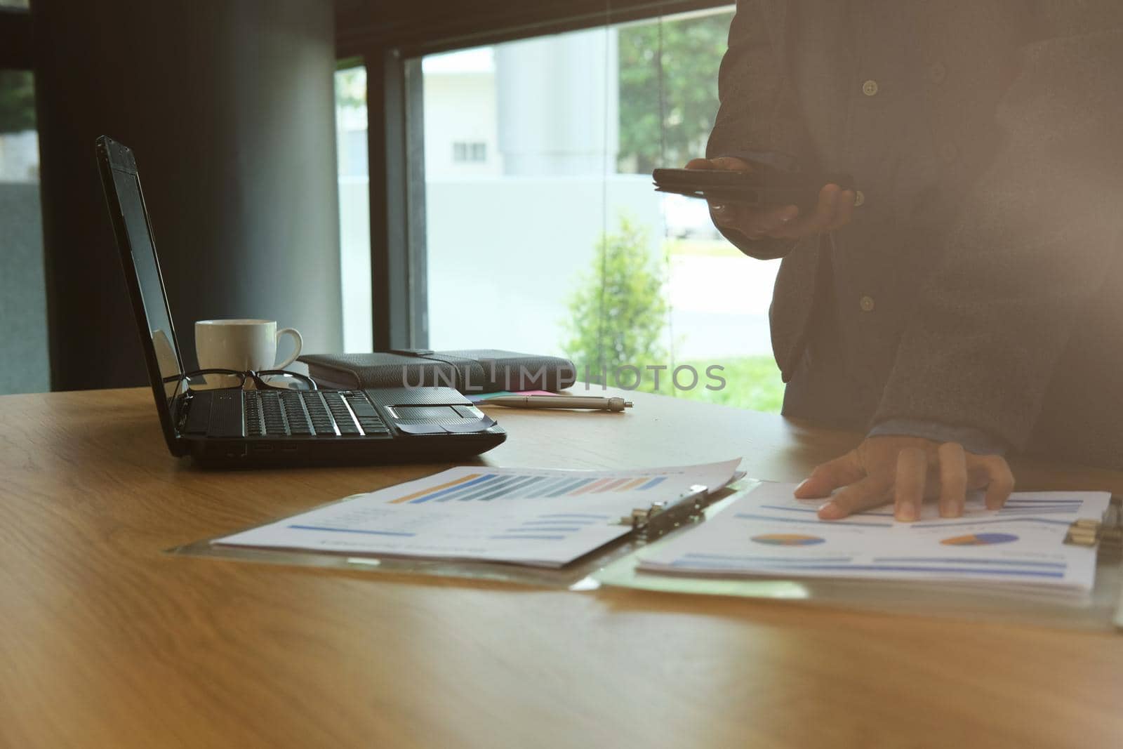 man working organizing plan with smart phone. businessman analyzing document at workplace coworking office