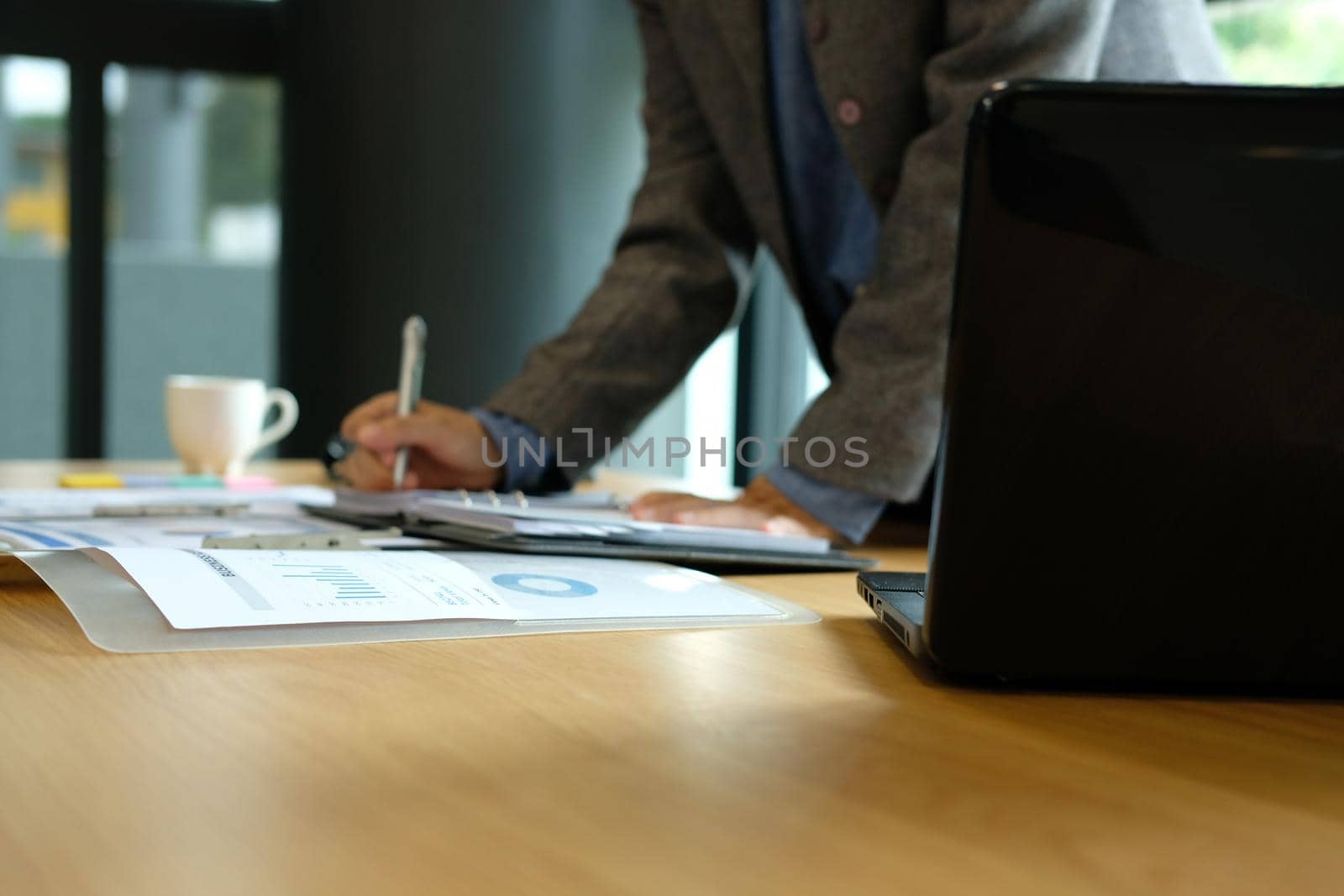 man writing reminder schedule note on notebook. businessman working organizing plan at workplace coworking office