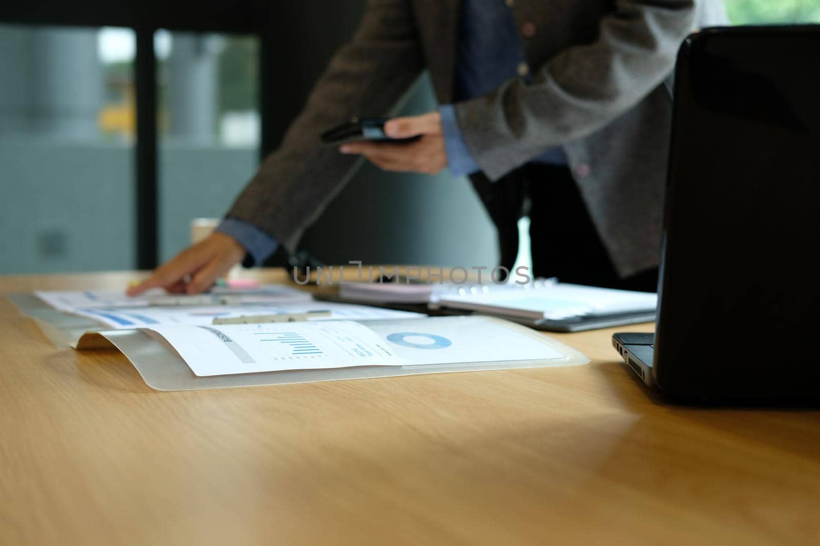 man working organizing plan with smart phone. businessman analyzing document at workplace coworking office