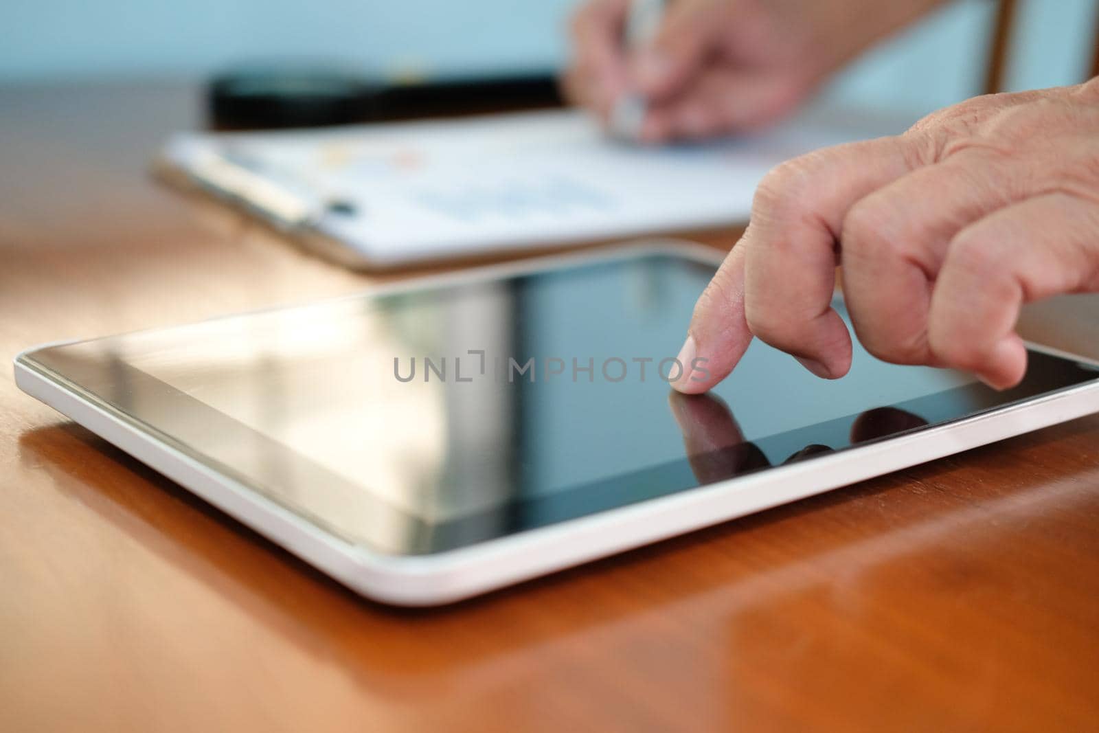 man working with tablet at office. businessman analyzing chart document at workplace. by pp99