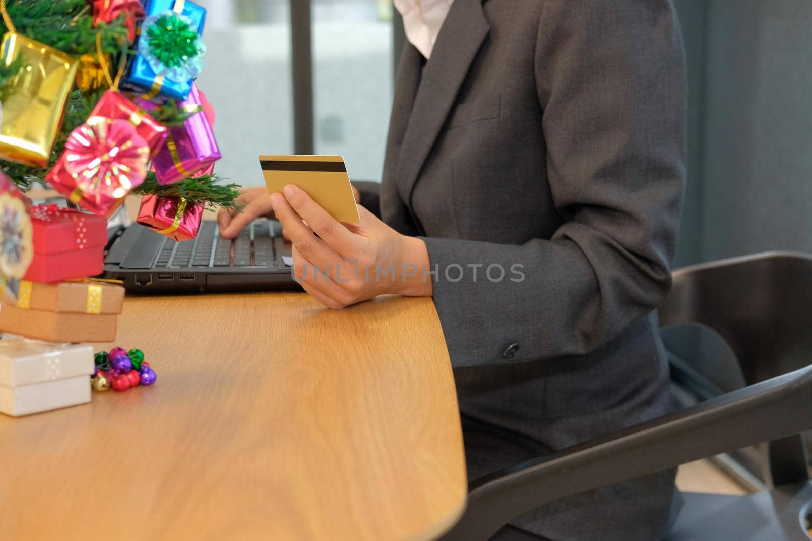 woman holding credit card using computer for online shopping. businesswoman buying on internet, make payment on website during christmas new year holiday