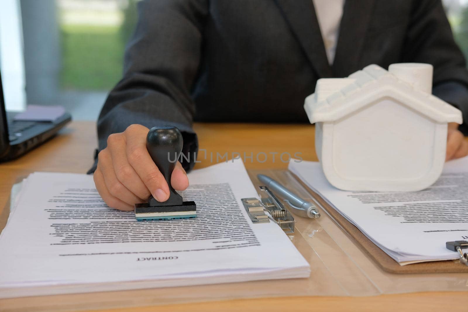 real estate agent using stamper for stamping approved on mortgage loan contract agreement document