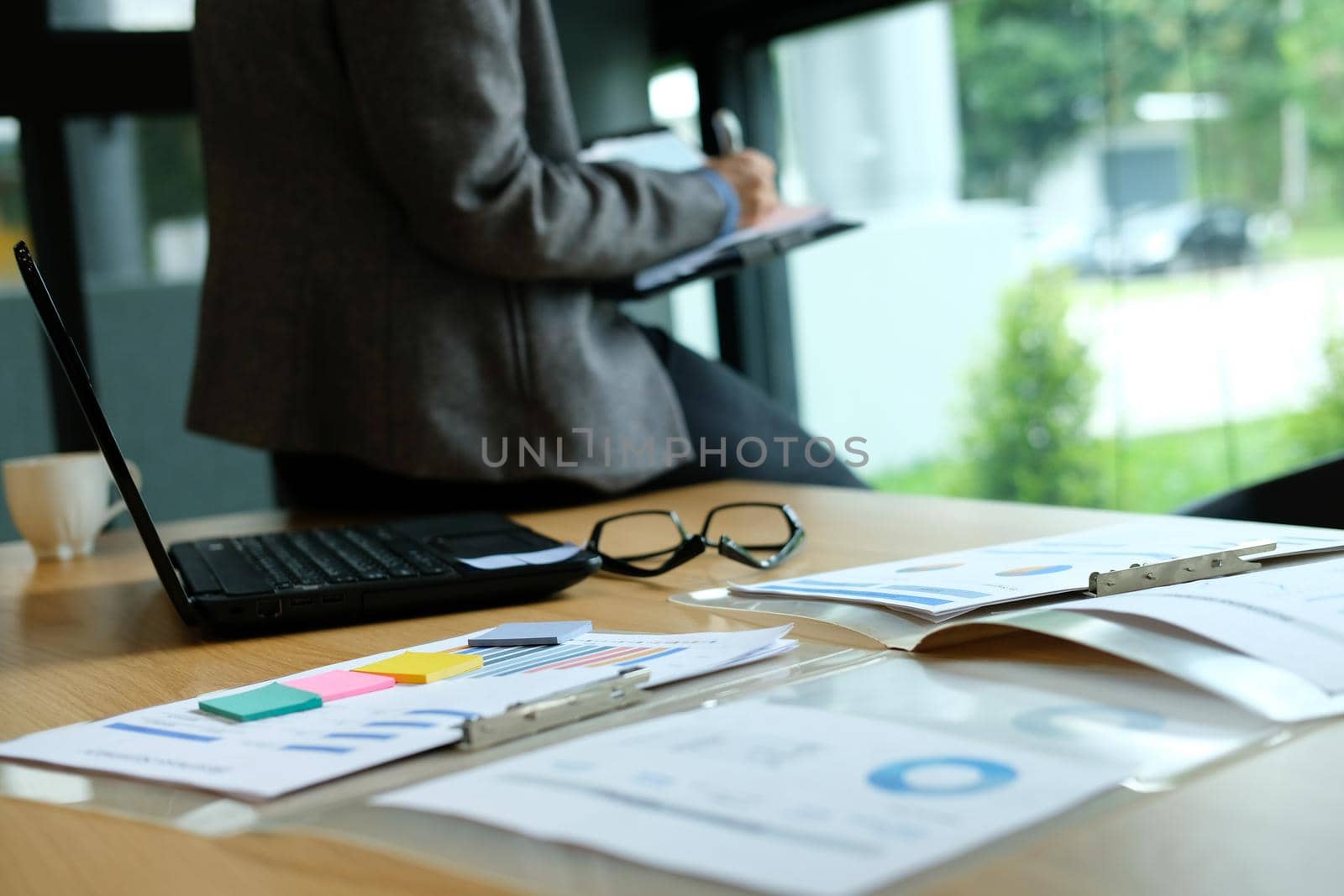 man writing reminder schedule note on notebook. businessman working organizing plan at workplace coworking office