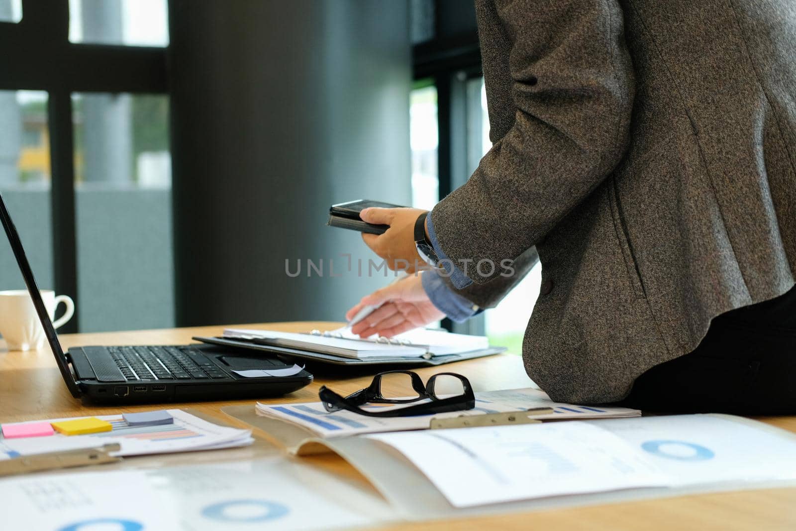 man organizing plan with notebook & smart phone. businessman working  at workplace coworking office