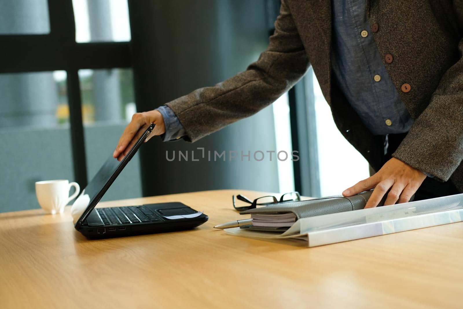buinesswoman holding notebook & closing computer after finishing work