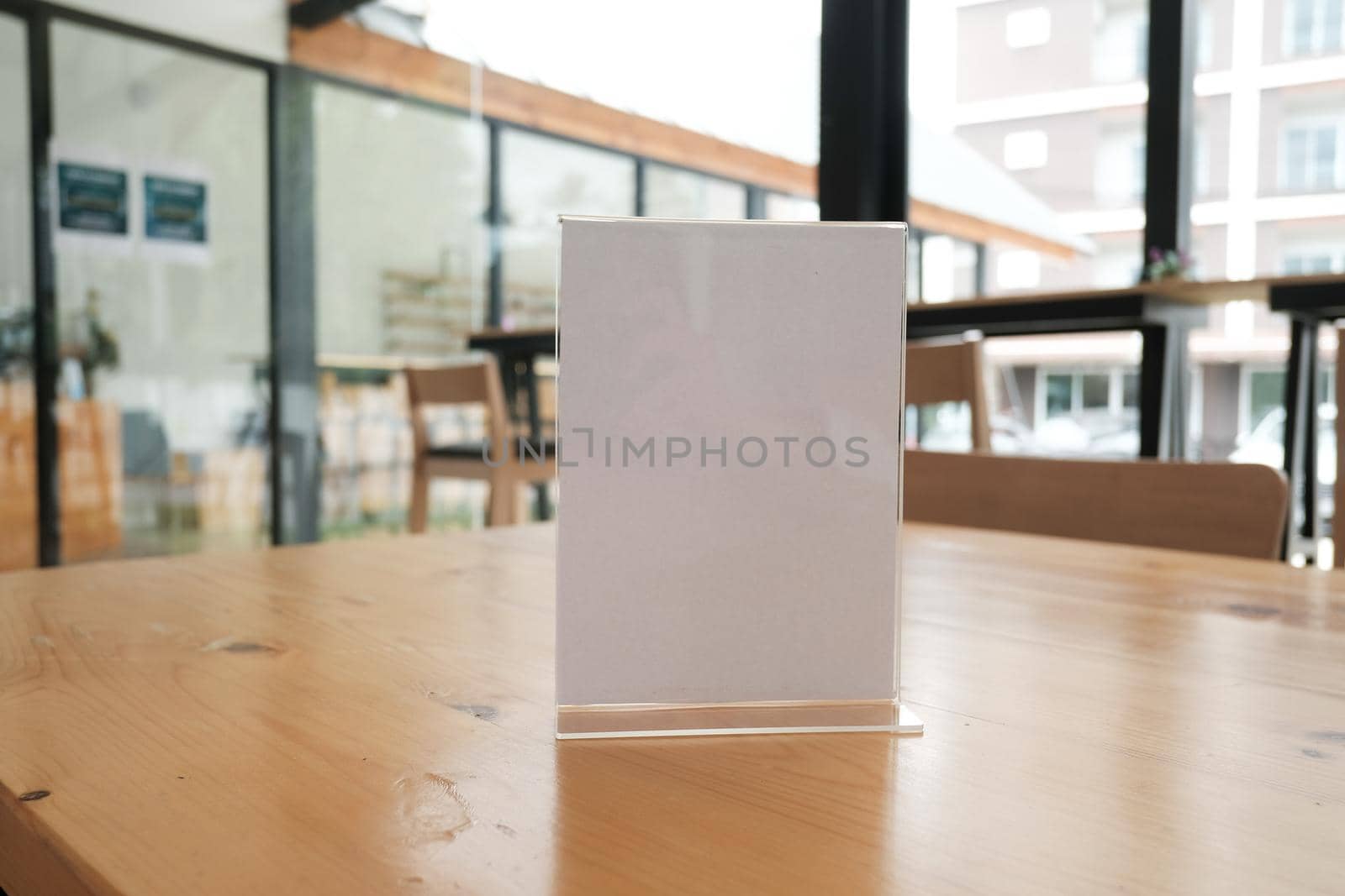 white label in cafe. display stand for acrylic tent card in coffee shop. mockup menu frame on table in bar restaurant. space for text