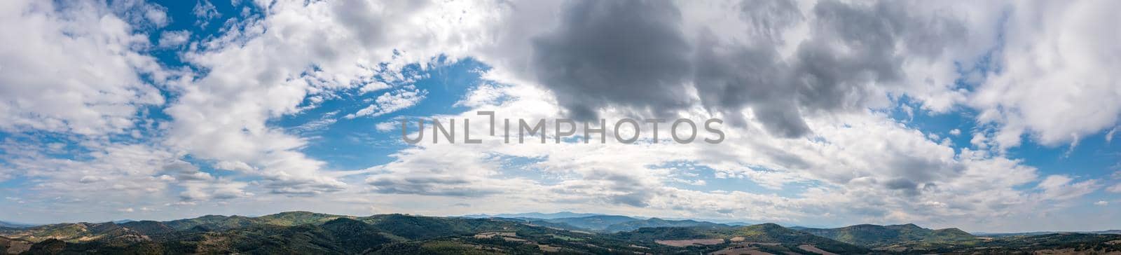 Banner view of blue sky with fluffy clouds over the land