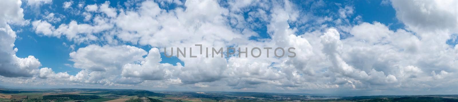 Banner view of blue sky with fluffy clouds over the land