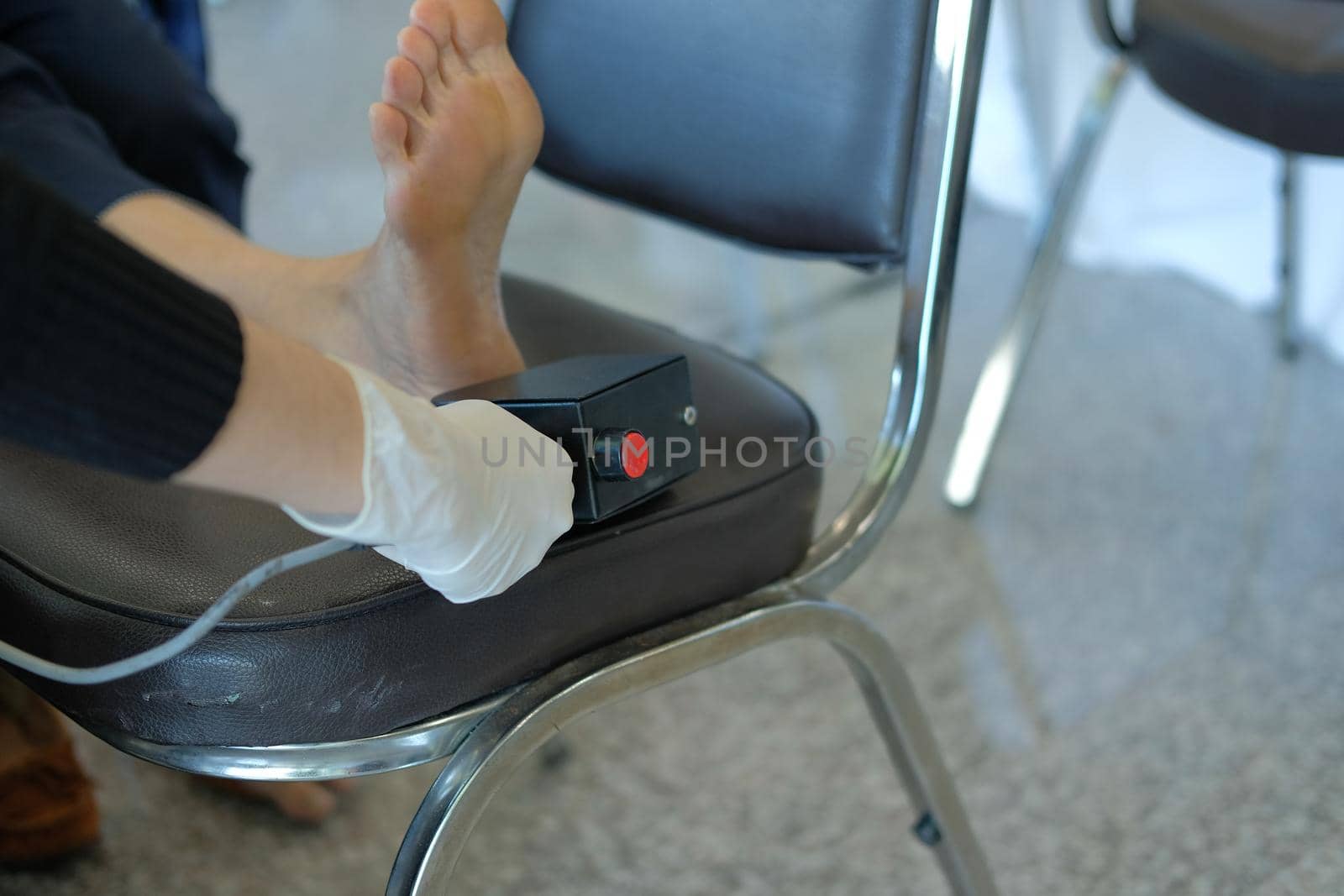 nurse measuring appreciation vibration threshold on woman foot with biothesiometer instument to check neurological disease