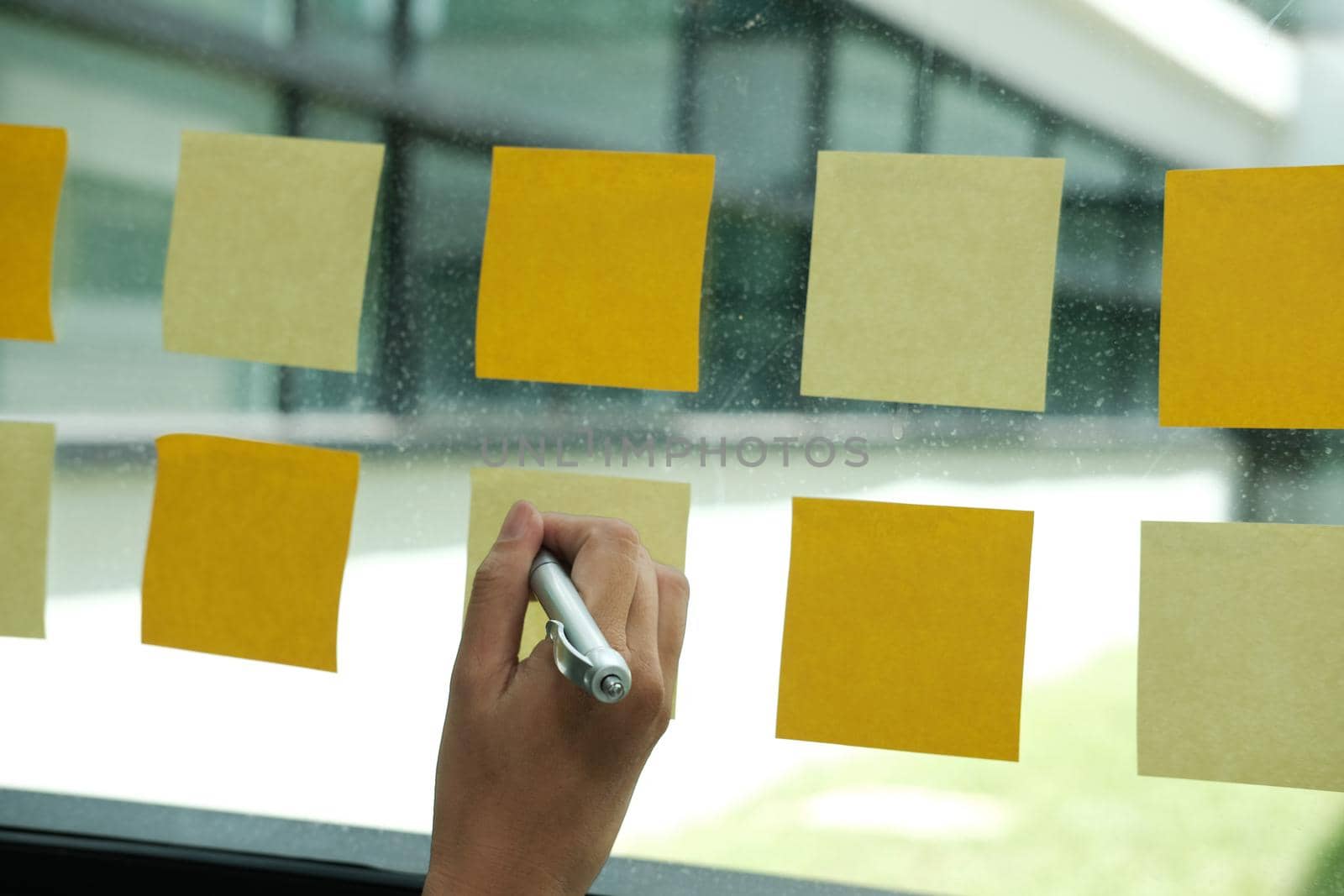 hand write on adhesive notes on glass wall. Sticky note paper reminder schedule for discussing creative idea & business brainstorming by pp99