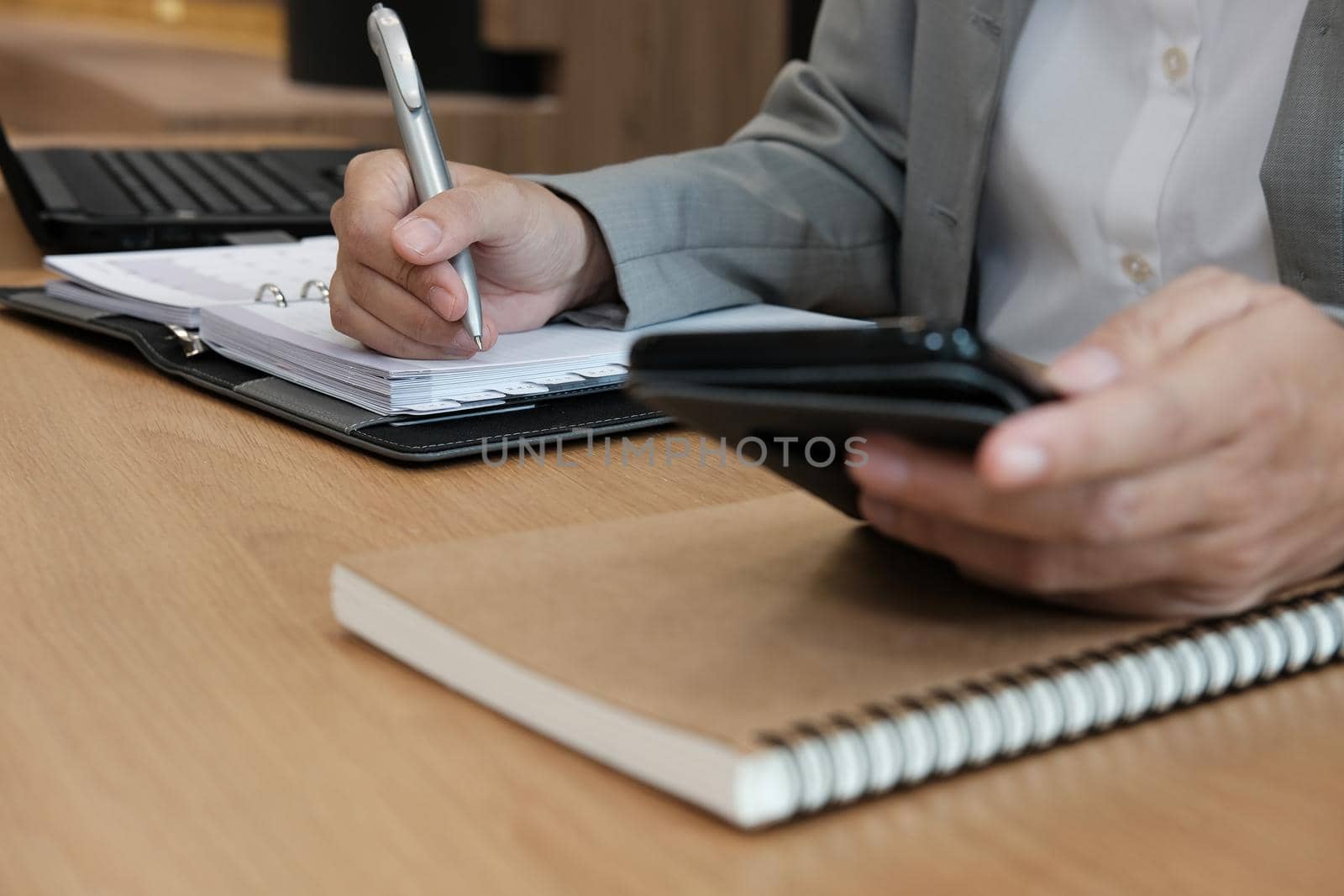 man writing reminder schedule note on notebook. businessman working organizing plan with smart phone at workplace by pp99