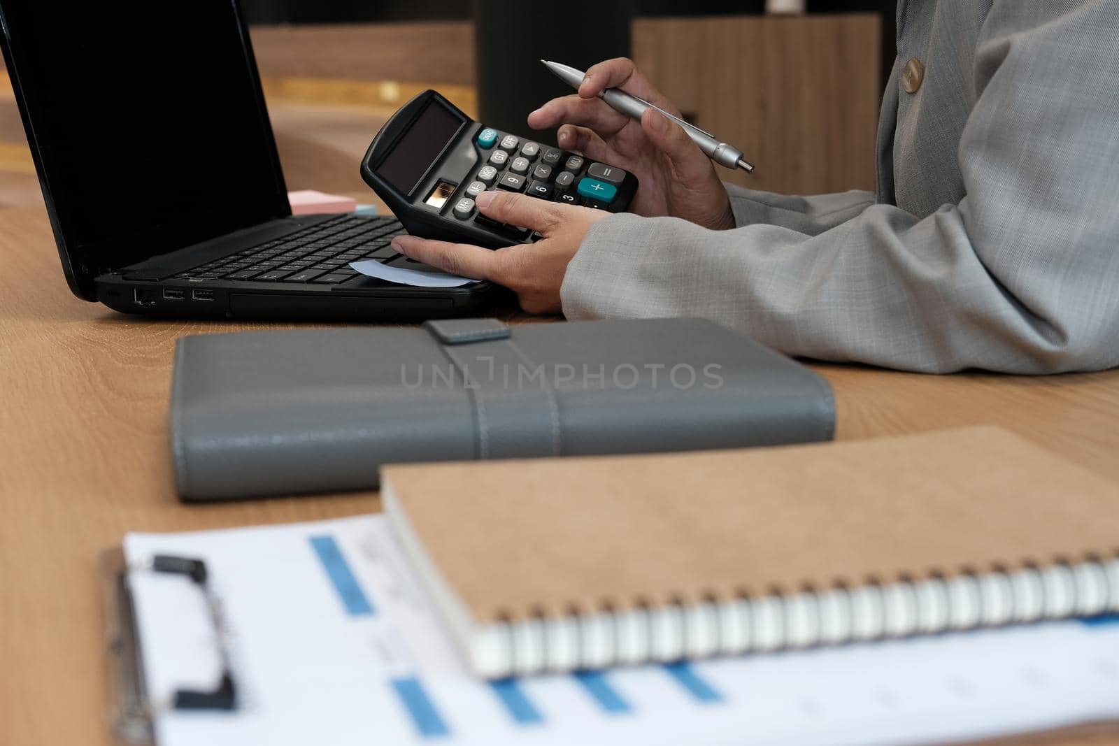 financial adviser use calculator to calculate revenue & budget. accountant doing accounting. bookkeeper making calculation. finance & economy concept by pp99