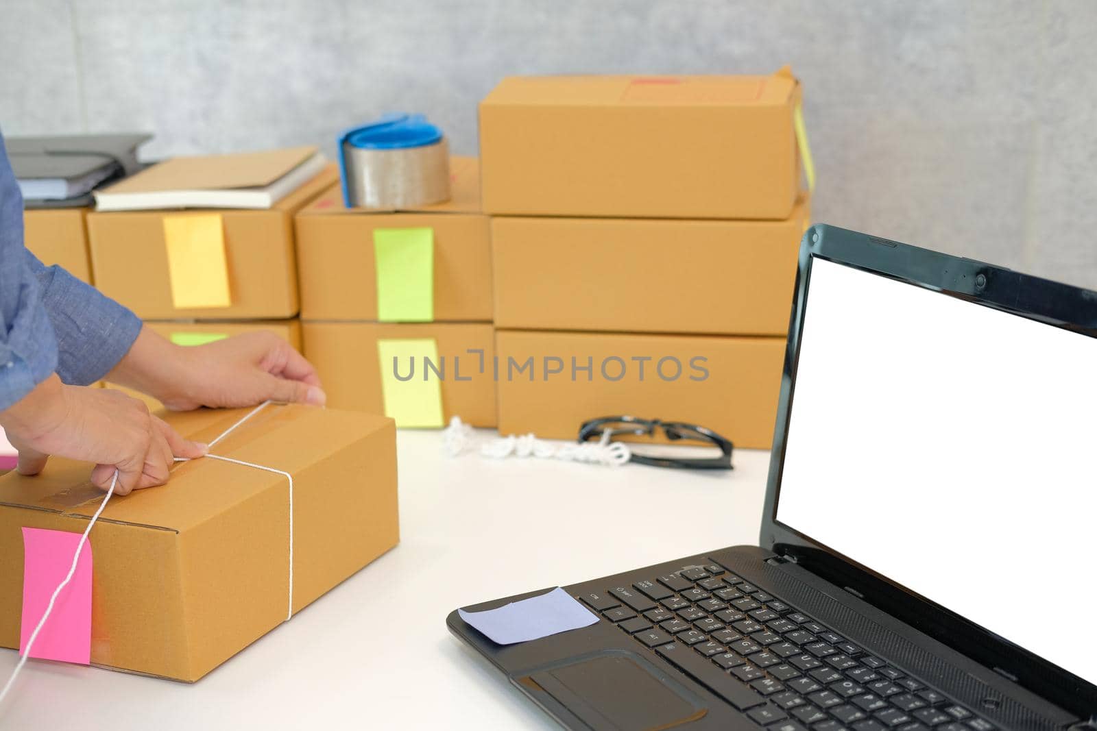 startup small business owner packing cardboard box at workplace. freelance woman entrepreneur seller prepare product parcel box for deliver to customer. Online selling, e-commerce concept