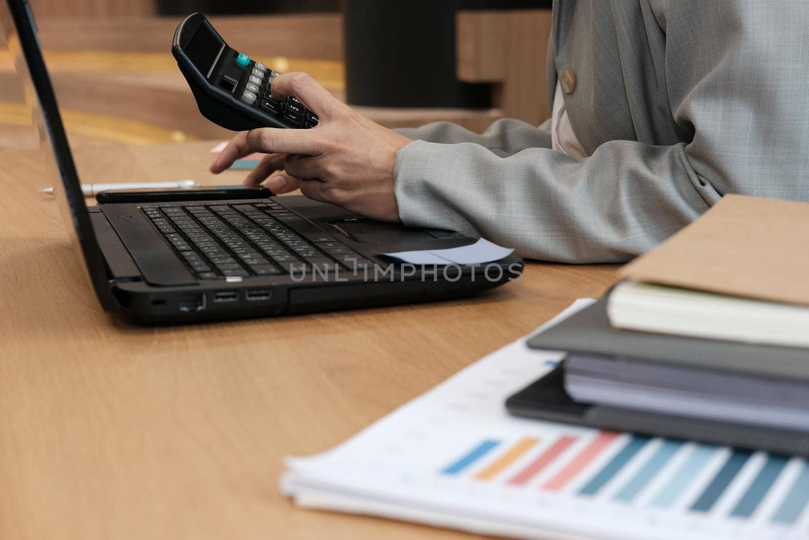 financial adviser working with calculator at office. accountant doing accounting & calculating revenue & budget. bookkeeper making calculation. finance & economy concept