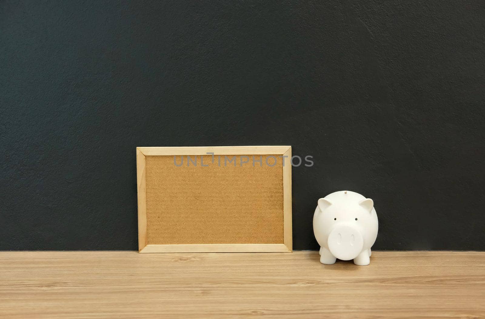 cork board piggy bank on wooden desk. money saving finance investment concept