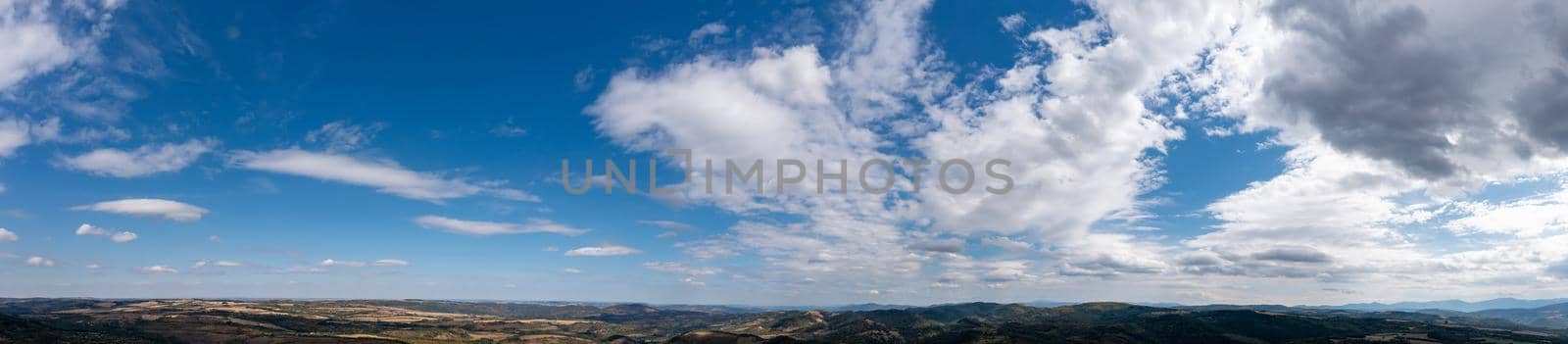 Banner view of blue sky with fluffy clouds over the hills