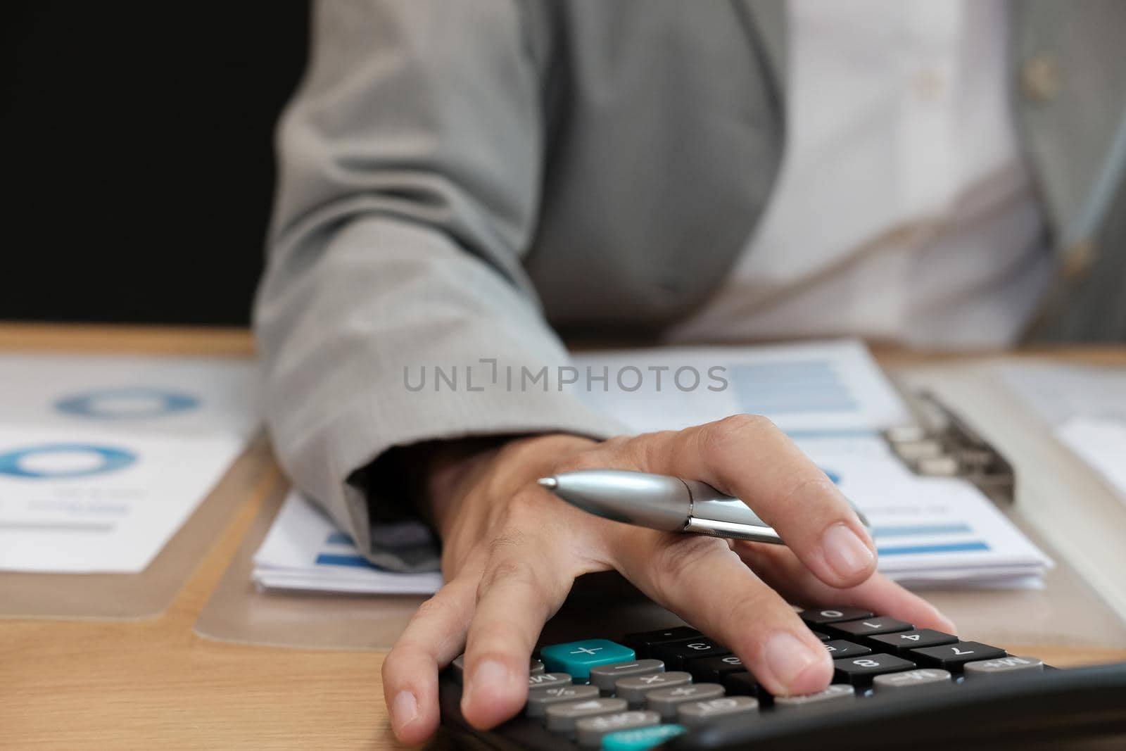 financial adviser working with calculator, business document at office. accountant doing accounting & calculating revenue & budget. bookkeeper making calculation. finance & economy concept