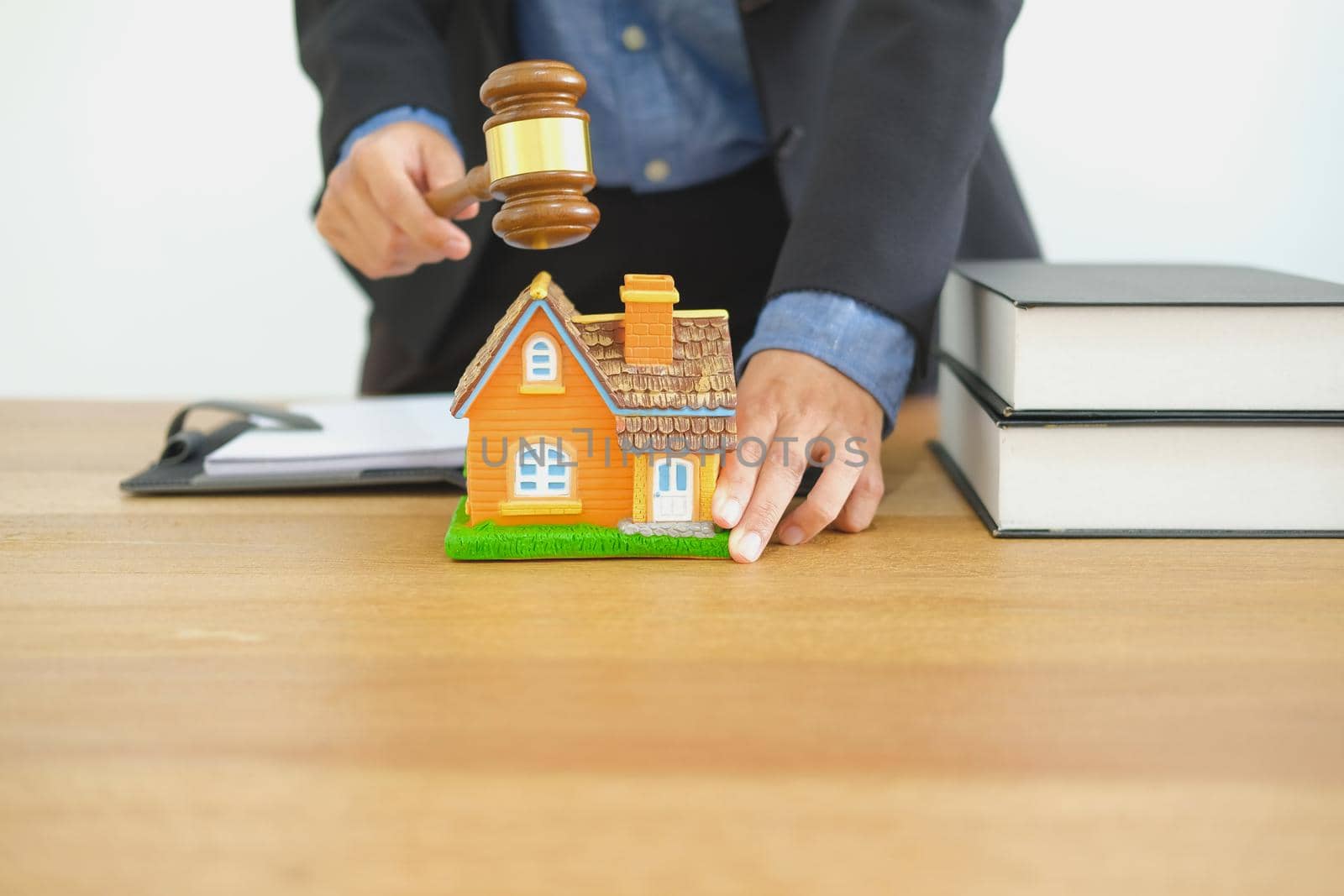 lawyer with judge gavel knocking house model. real estate dispute & property auction concept by pp99