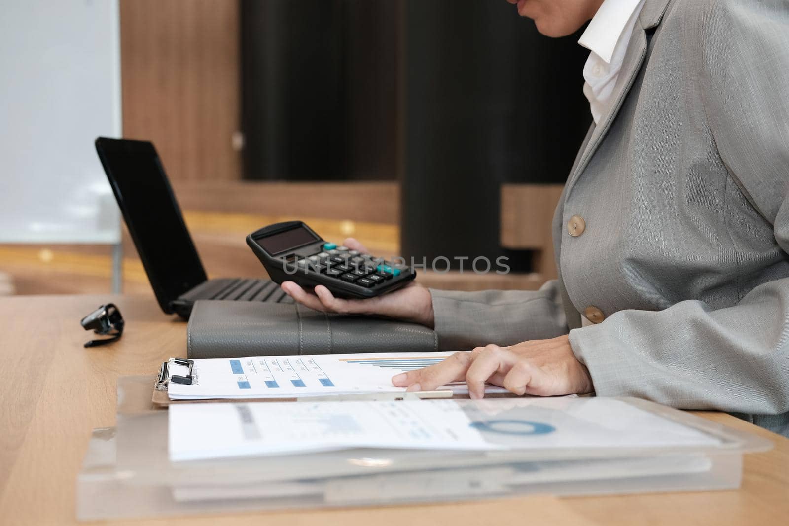 financial adviser working with calculator, business document at office. accountant doing accounting & calculating revenue & budget. bookkeeper making calculation. finance & economy concept