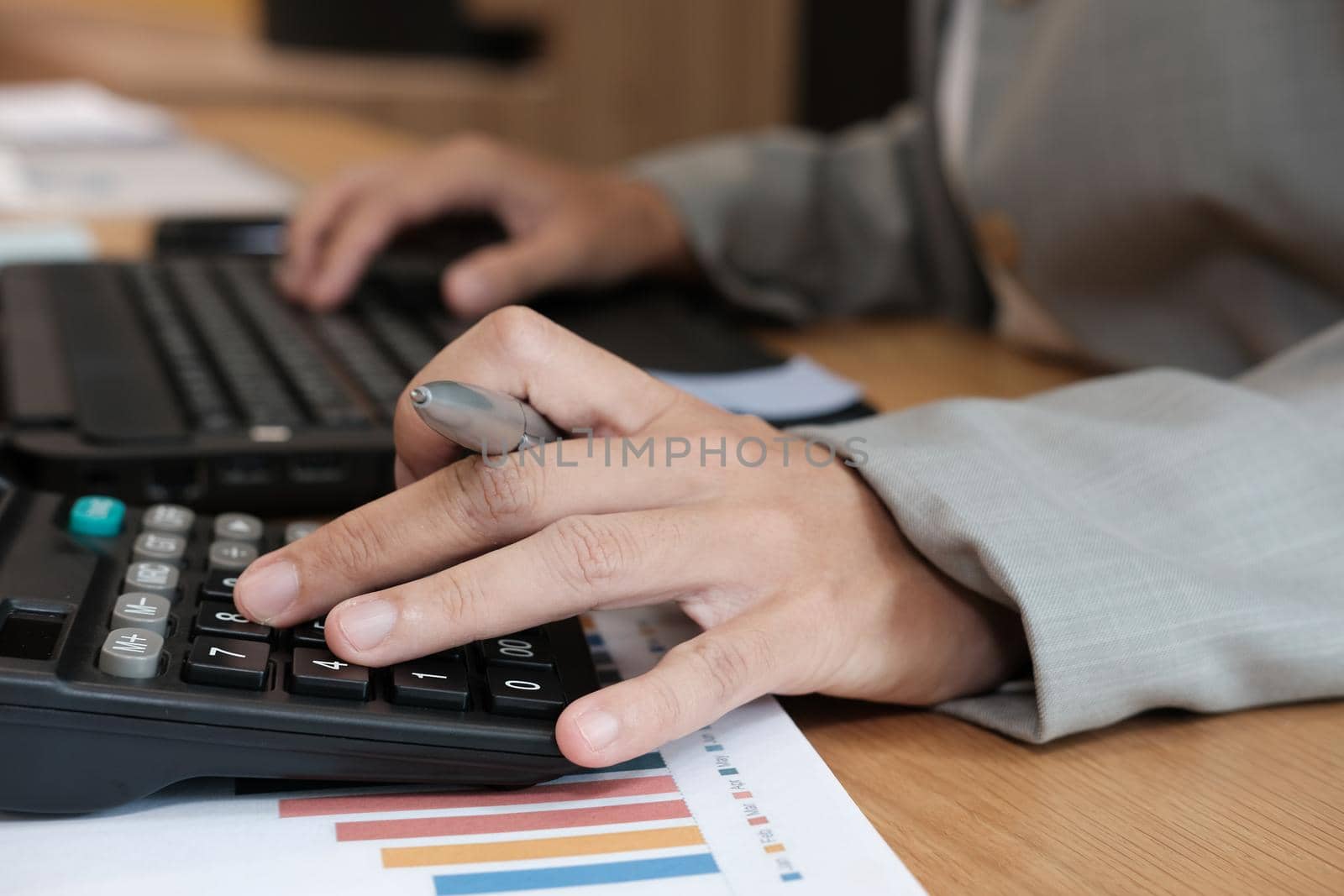 financial adviser working with calculator & computer. accountant doing accounting & calculating revenue & budget. finance & economy concept by pp99