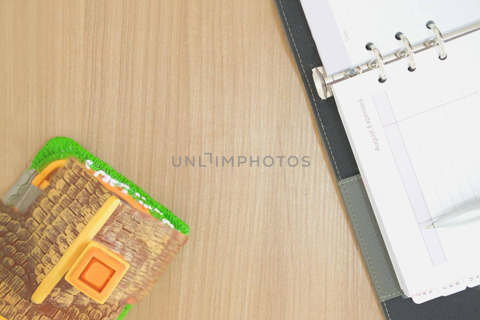 notebook & house model on wooden desk. realtor real estate agent workplace. buying selling & renting property