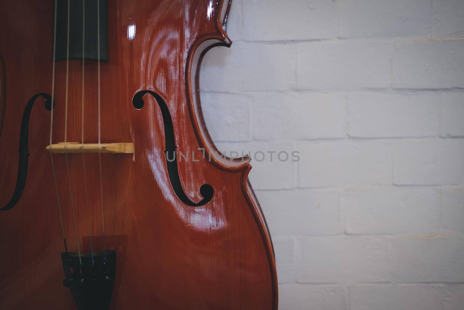 brown cello near red wall. music instrument by pp99