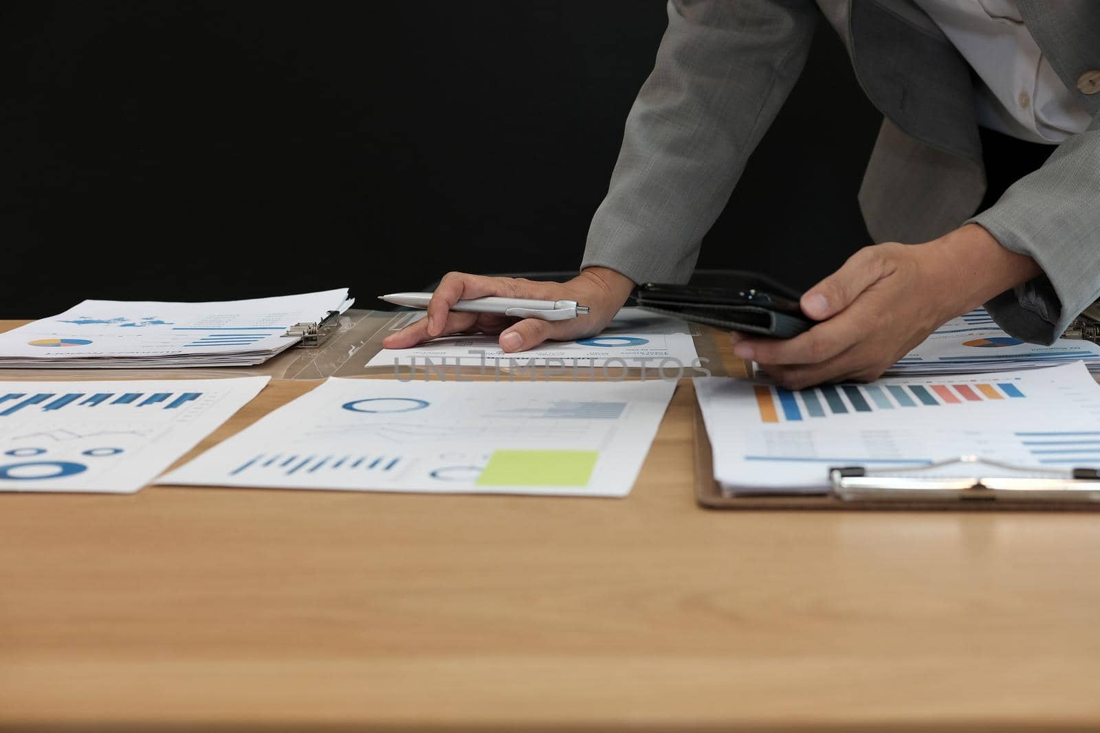 man working organizing plan with smart phone. businessman analyzing document at workplace coworking office