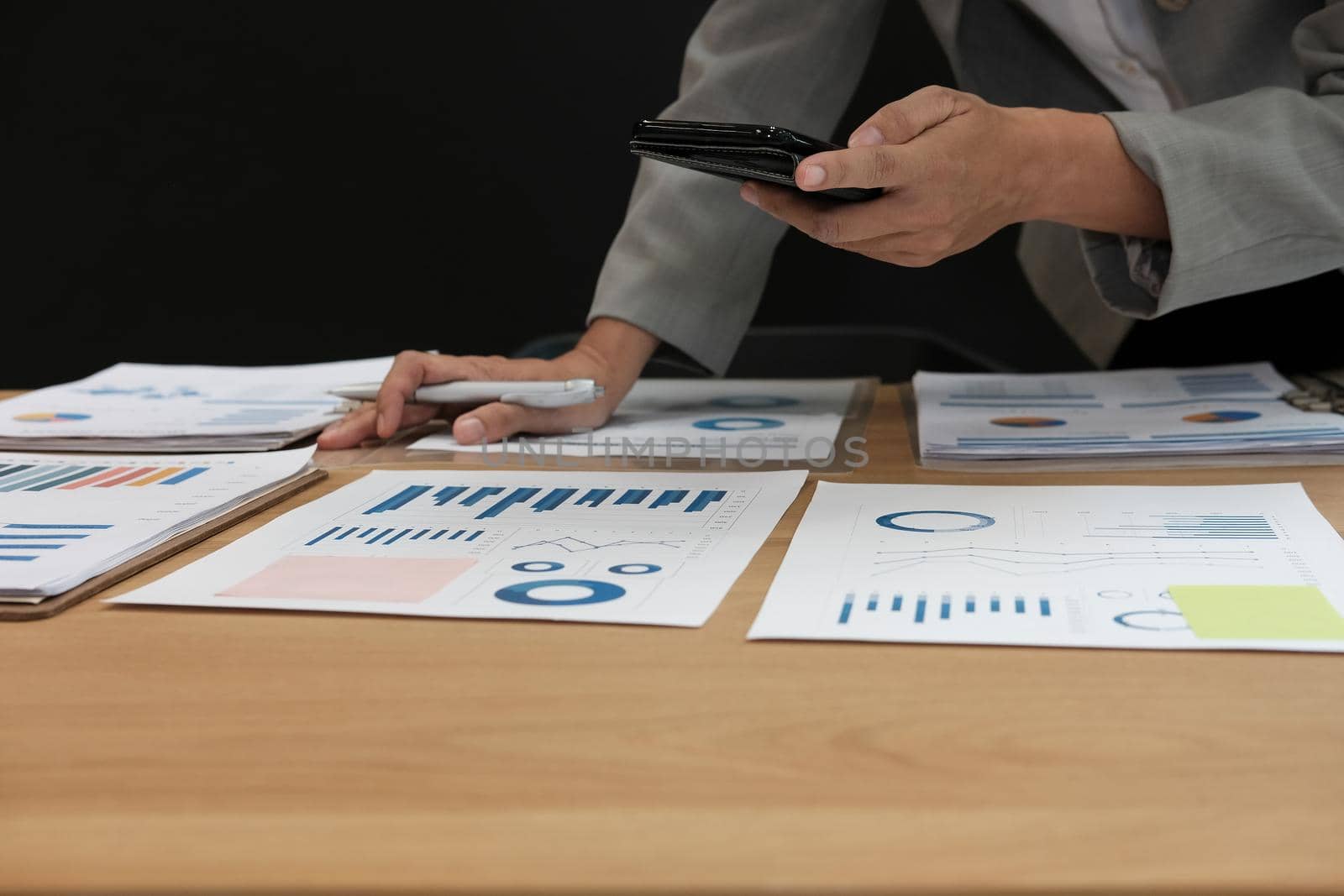 man working organizing plan with smart phone. businessman analyzing document at workplace coworking office