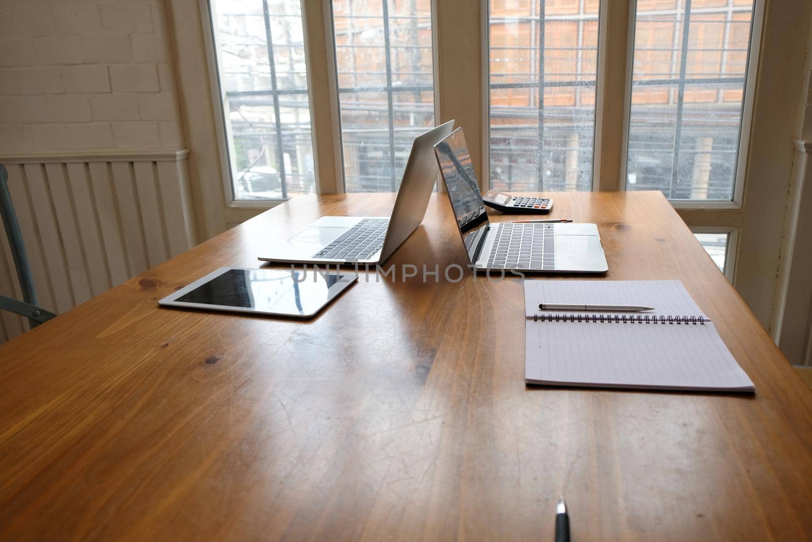 tablet, computer laptop on wood office desk near window. wokring space concept