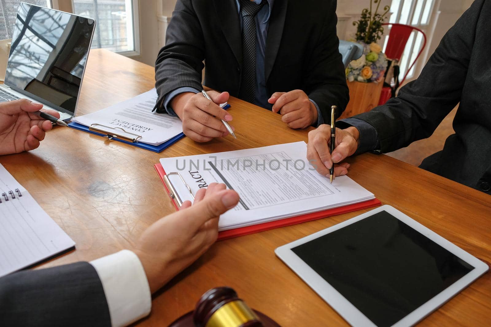 businessman consulting lawyer & signing contract agreement. judge gavel & team meeting at law firm